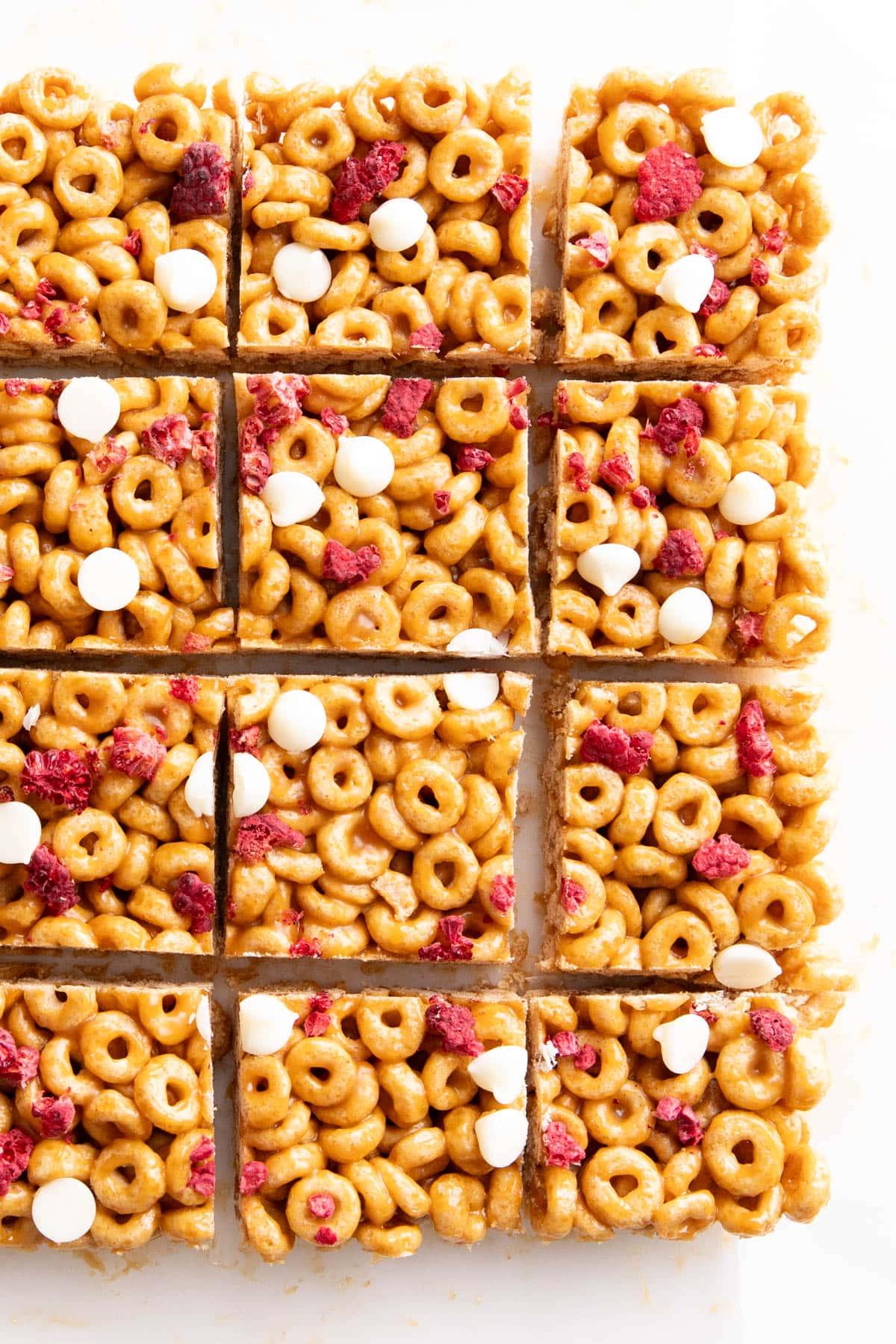 Müsliriegel Rezept – Gesund & Einfach! 2 Reihen von Müsliriegeln mit Cheerios, belegt mit Trockenfrüchten und Schokoladenstückchen