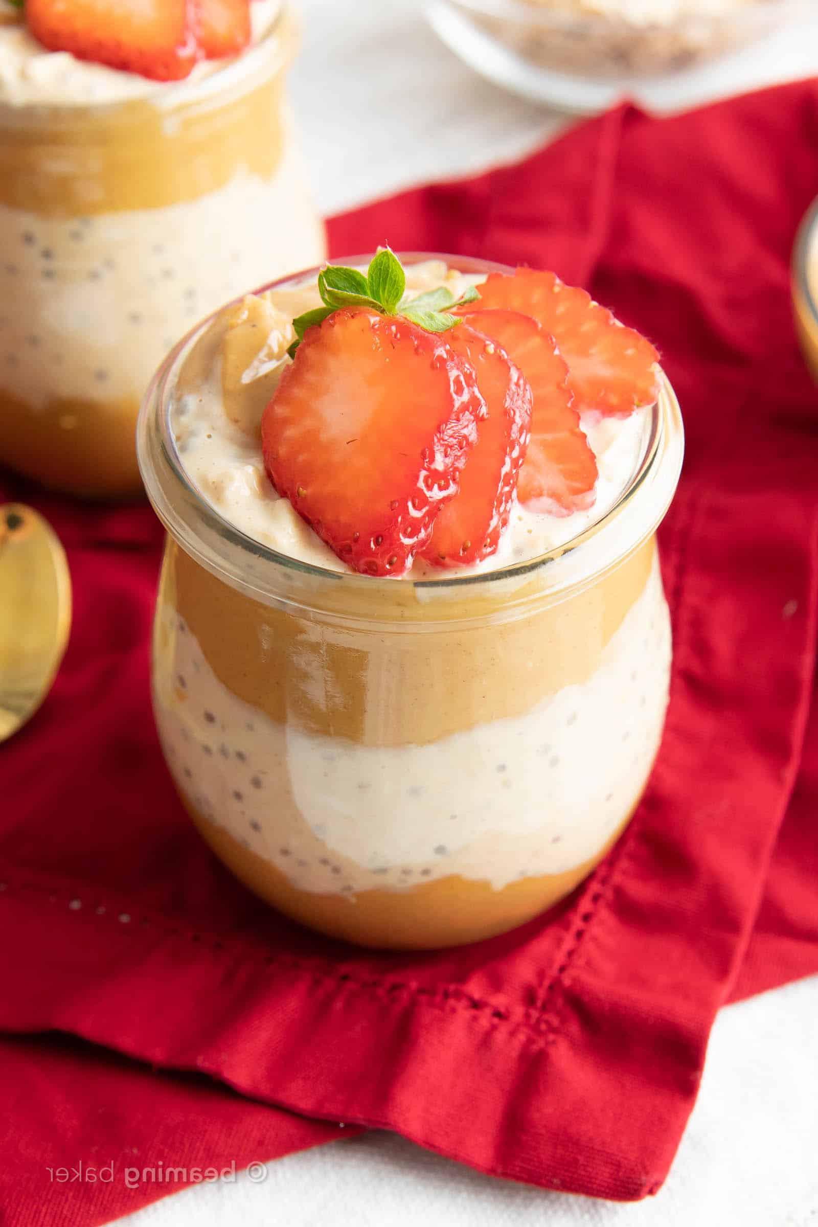 Ein schräger Blick auf ein Glas Erdnussbutter Overnight Oats auf einem roten Tuch