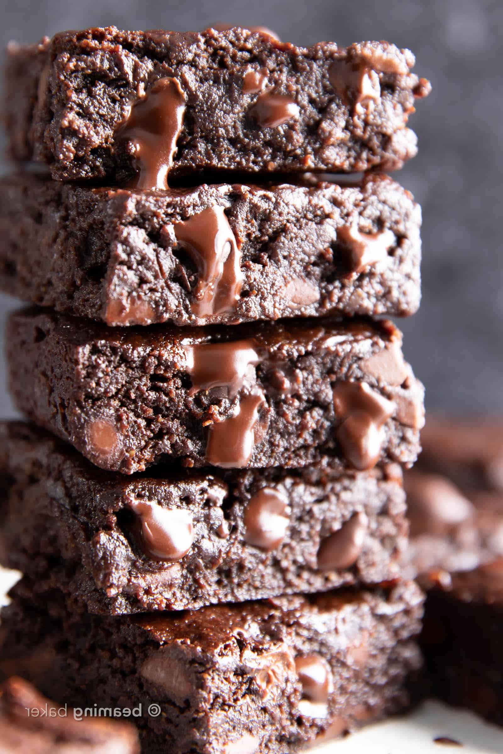 Vegane glutenfreie Brownies 2 Closeup-Stapel frisch gebackener veganer glutenfreier Brownies, aus denen geschmolzene Schokoladenstückchen quellen