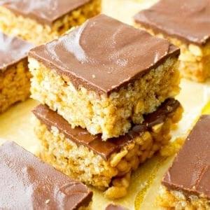 **Erdnussbutter-Schoko-Reis-Crispy-Riegel (Vegan, Glutenfrei, Milchfrei)** 11 Vegane, glutenfreie und milchfreie Erdnussbutter-Schoko-Reis-Crispy-Quadrate: Ein einfaches 5-Zutaten-Rezept für mit Schokolade überzogene PB-Reis-Crispy-Quadrate, die wie Erdnussbutter-Cups schmecken. #Vegan #Glutenfrei #Milchfrei | BeamingBaker.com