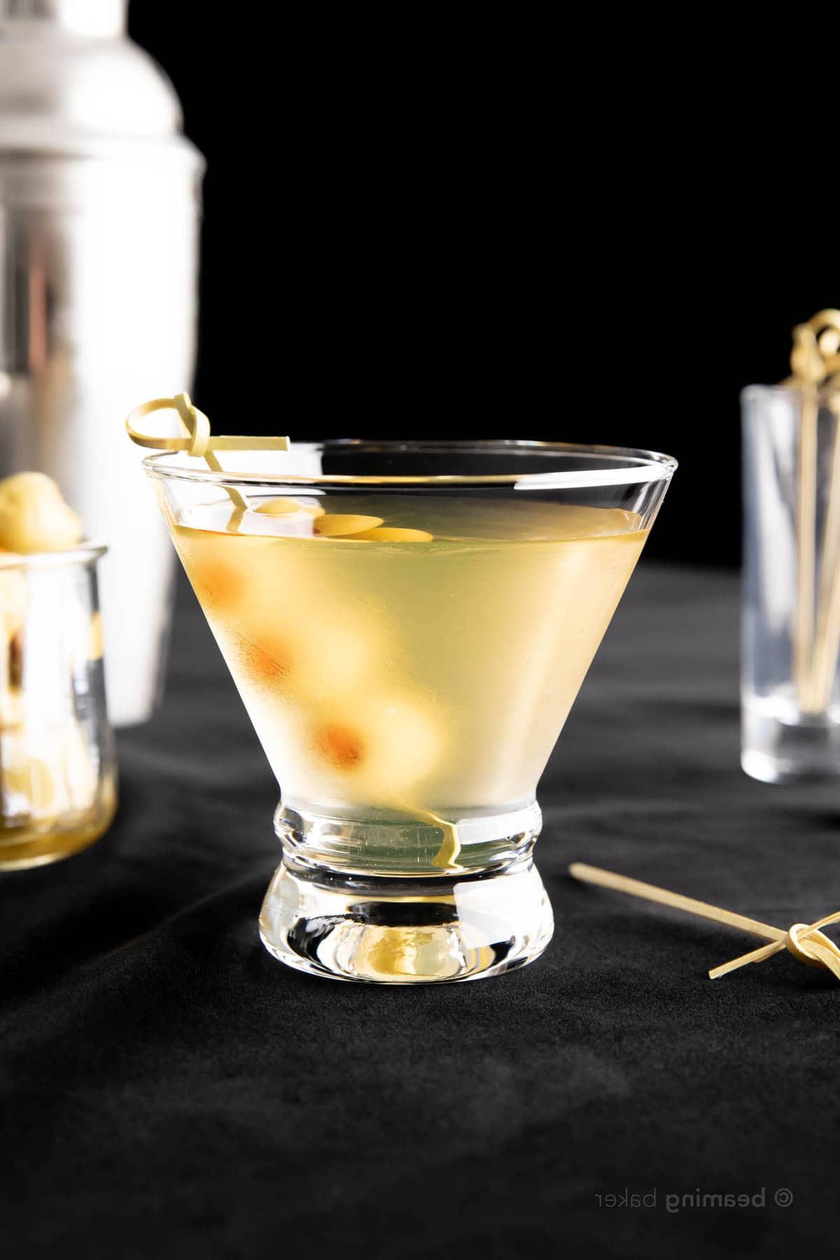 Extra Schmutziger Martini 3 Ein kurzes Martini-Glas gefüllt mit Extra Dirty Martini mit einem Bambus-Spieß