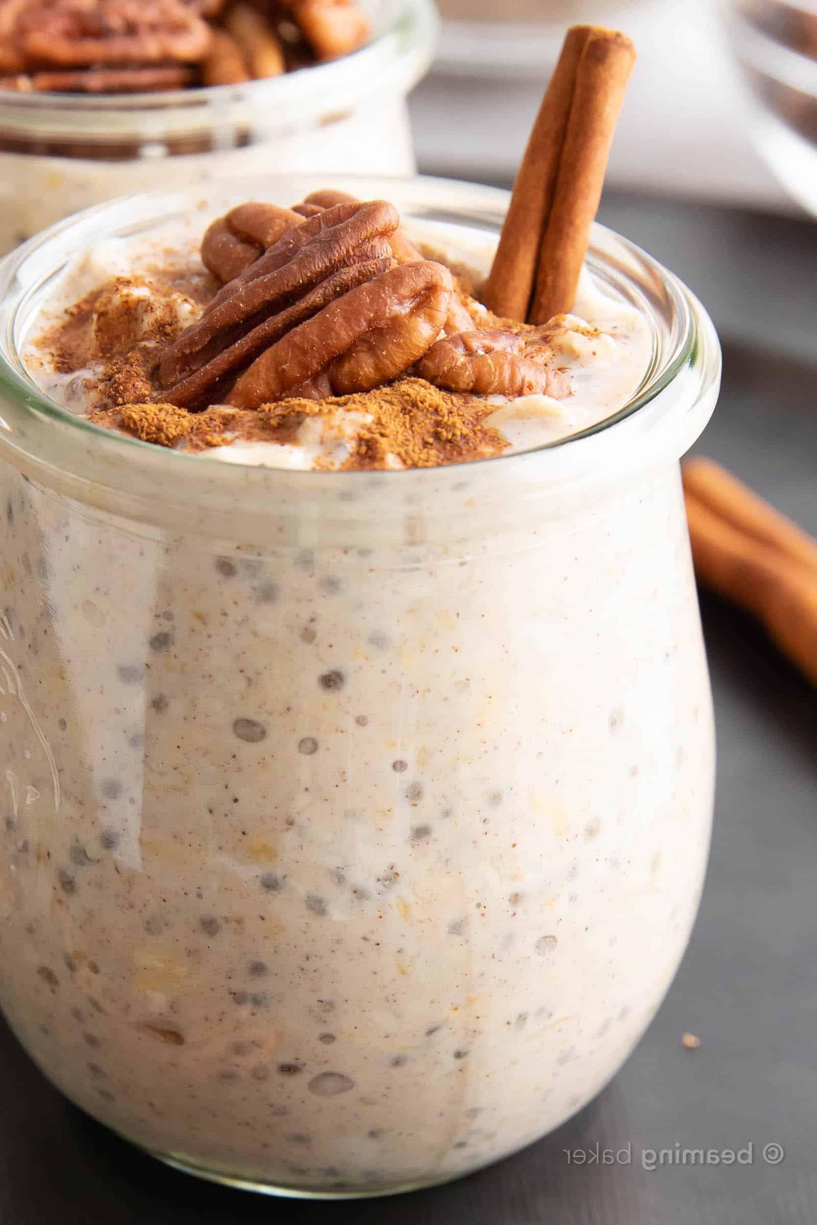 Ahorn-Pekannuss-Overnight-Oats 3 Super Nahaufnahme eines Glases Ahorn-Pekannuss Overnight Oats, garniert mit Zimtstange und Pekannüssen