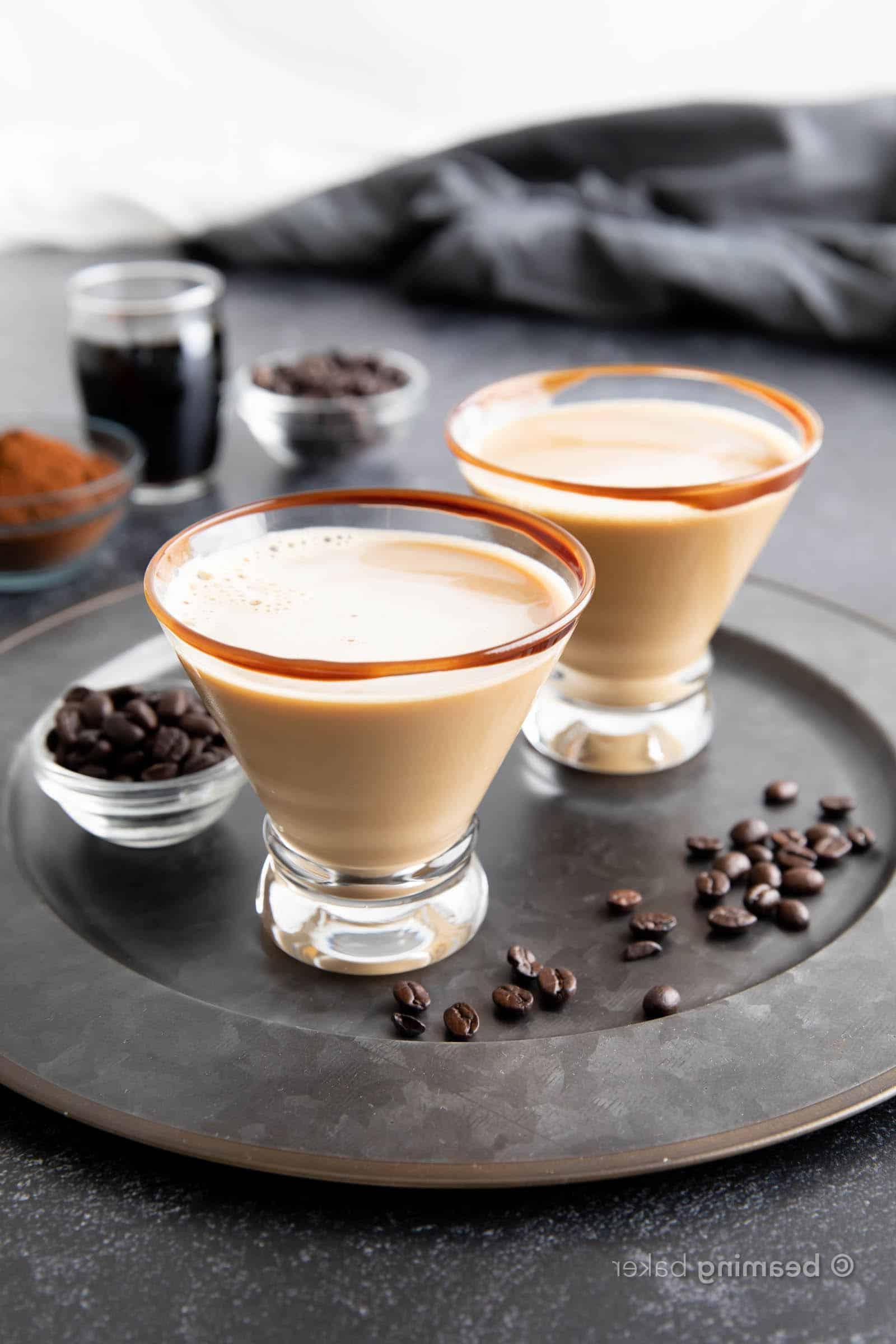 Schokoladen-Espresso-Martini-Rezept 4 Zwei Schokoladen Espresso Martinis, auf einem Teller mit Kaffeebohnen serviert