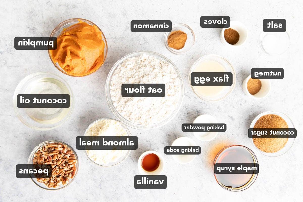 Veganer glutenfreier Kürbis-Streuselkuchen (Gesund) 4 Vegane Glutenfreie Kürbis-Streuselkuchen-Zutaten, vorgemessen in Glasschalen, darunter Kürbispüree, Kokosblütenzucker, Mehl, Leinsamen-Eier, Kokosöl und mehr.