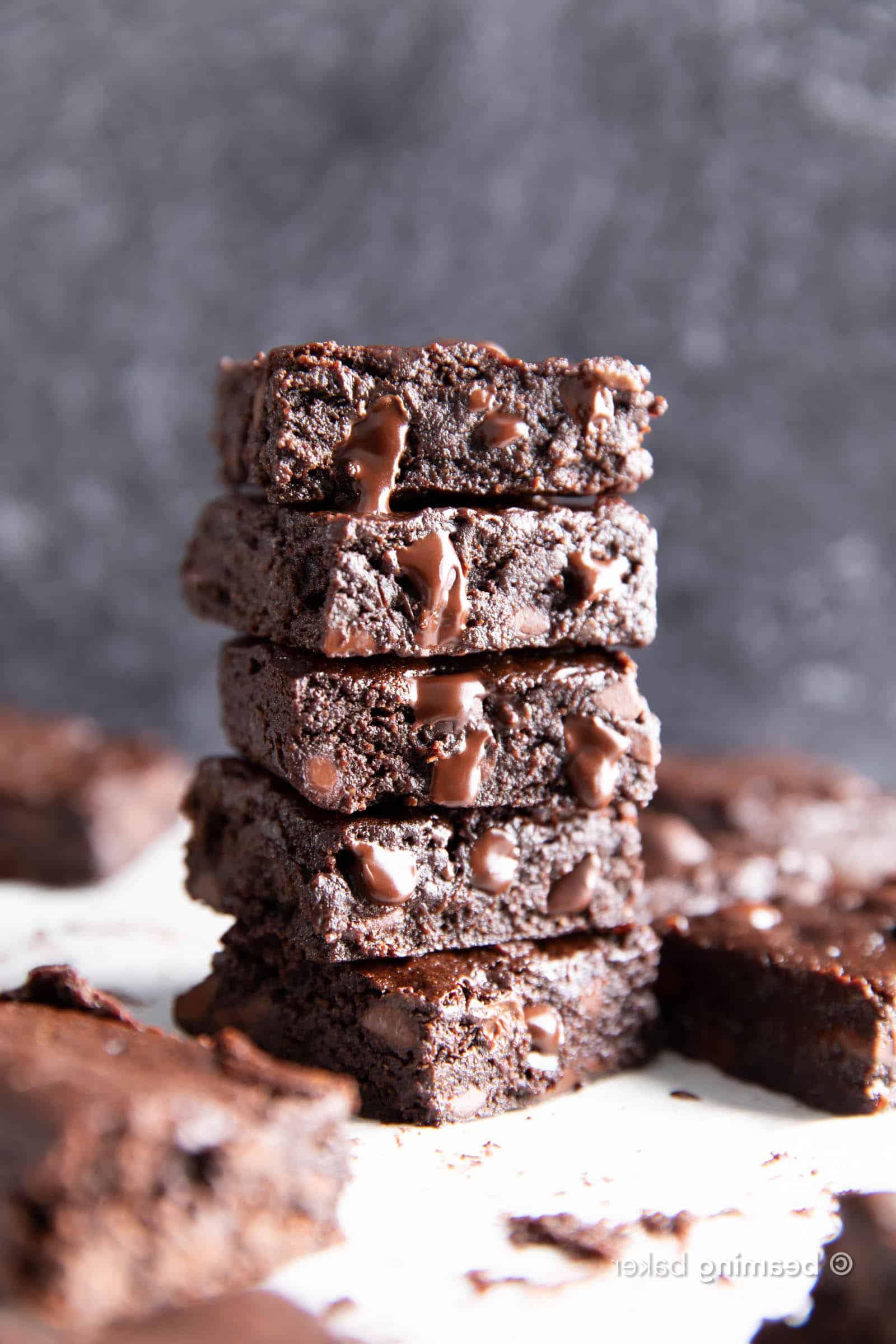 Vegane glutenfreie Brownies 5 Küchentisch voller veganer glutenfreier Brownies, gestapelt und verstreut