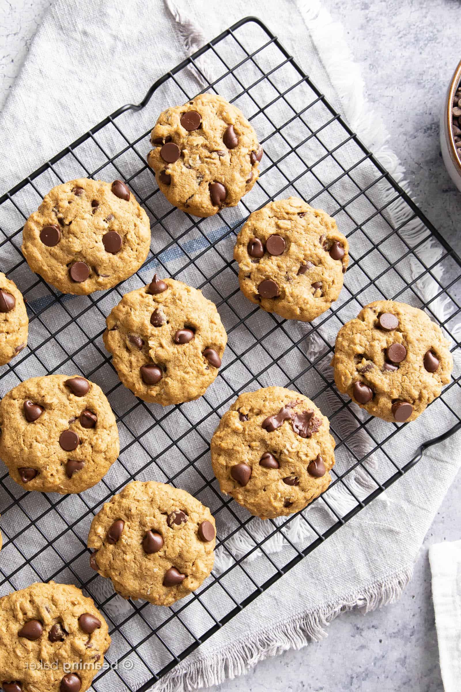 Soft baked oat flour chocolate chip cookies on black cooling rack