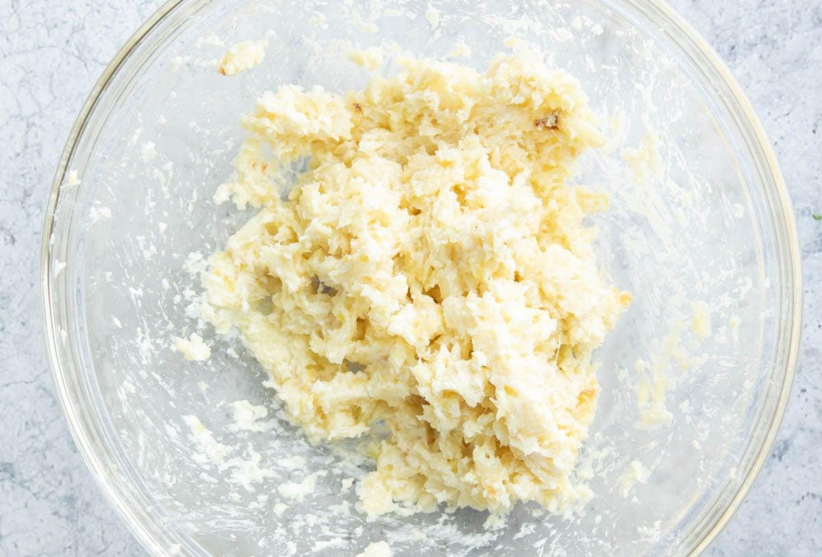 Geröstetes Knoblauchbrot {Hausgemachtes Rezept} 9 Zwei Fotos, die zeigen, wie man dieses Rezept zubereitet – fertige Butter in der Schüssel