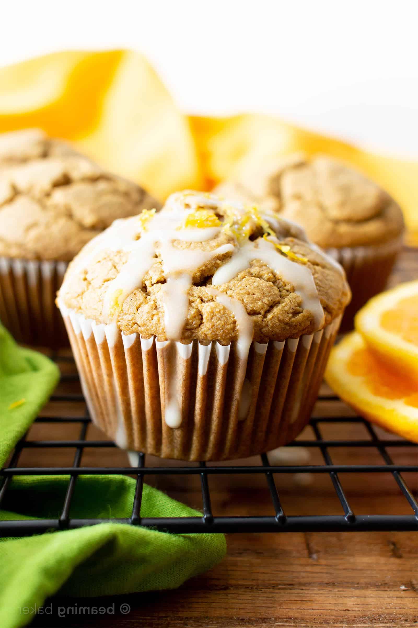 Glasur tropft von veganen glutenfreien Orangenmuffins auf einem Kühlgitter