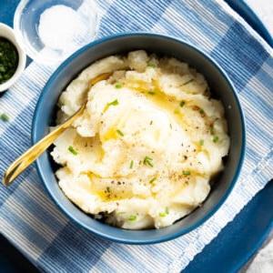 Veganes Kartoffelpüree (Milchfrei) 10 Schüssel mit veganem Kartoffelpüree, garniert mit geschmolzener veganer Butter und grünem Schnittlauch