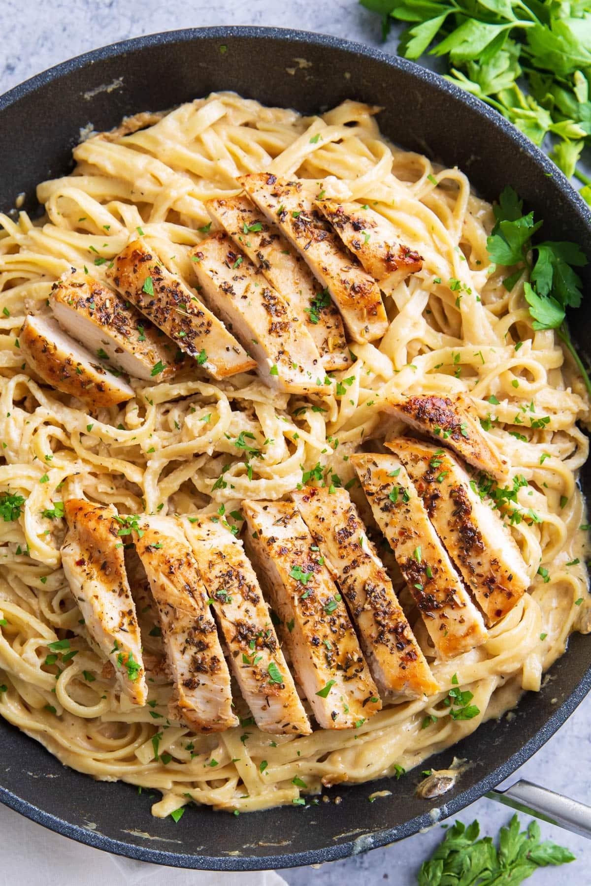 Leckeres Hähnchen-Fettuccine-Alfredo-Rezept 2 Dieses Hähnchen Fettuccine Alfredo Rezept in einer Pfanne, garniert mit geröstetem, kräuterigem Hähnchen, samtig-cremiger Alfredo-Soße und Unmengen an Fettuccine-Pasta.