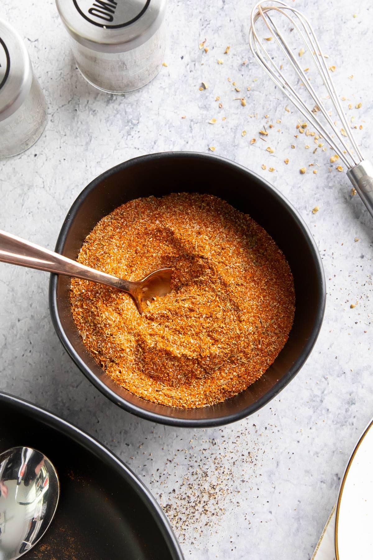 Cajun-Gewürzmischung Rezept 2 Eine pikante, aromatische Cajun-Würzmischung aus Louisiana, die in einer Schale mit einem Löffel serviert wird.