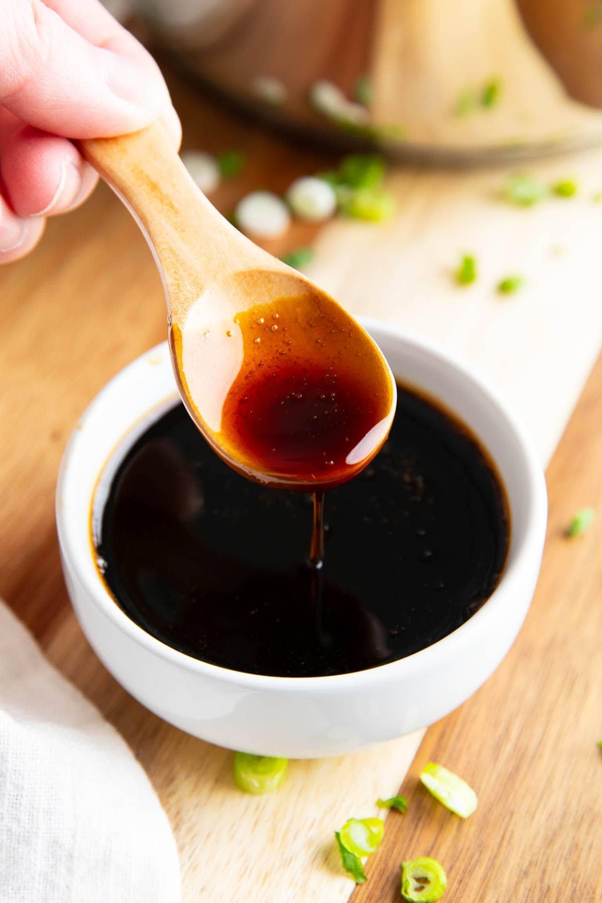 Aalsaucen-Rezept (Unagi-Sauce) 2 Jemand löffelt die dicke Aalsoße in eine Dippschale.