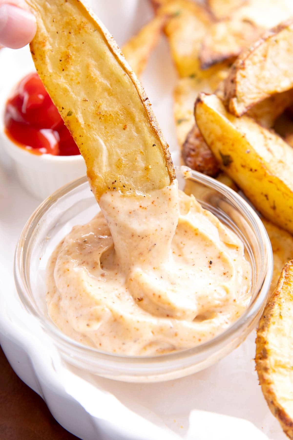 Chipotle Aioli 2 Eine knusprige Kartoffelspalte wird genüsslich in eine Schale voller cremiger Chipotle-Aioli getaucht