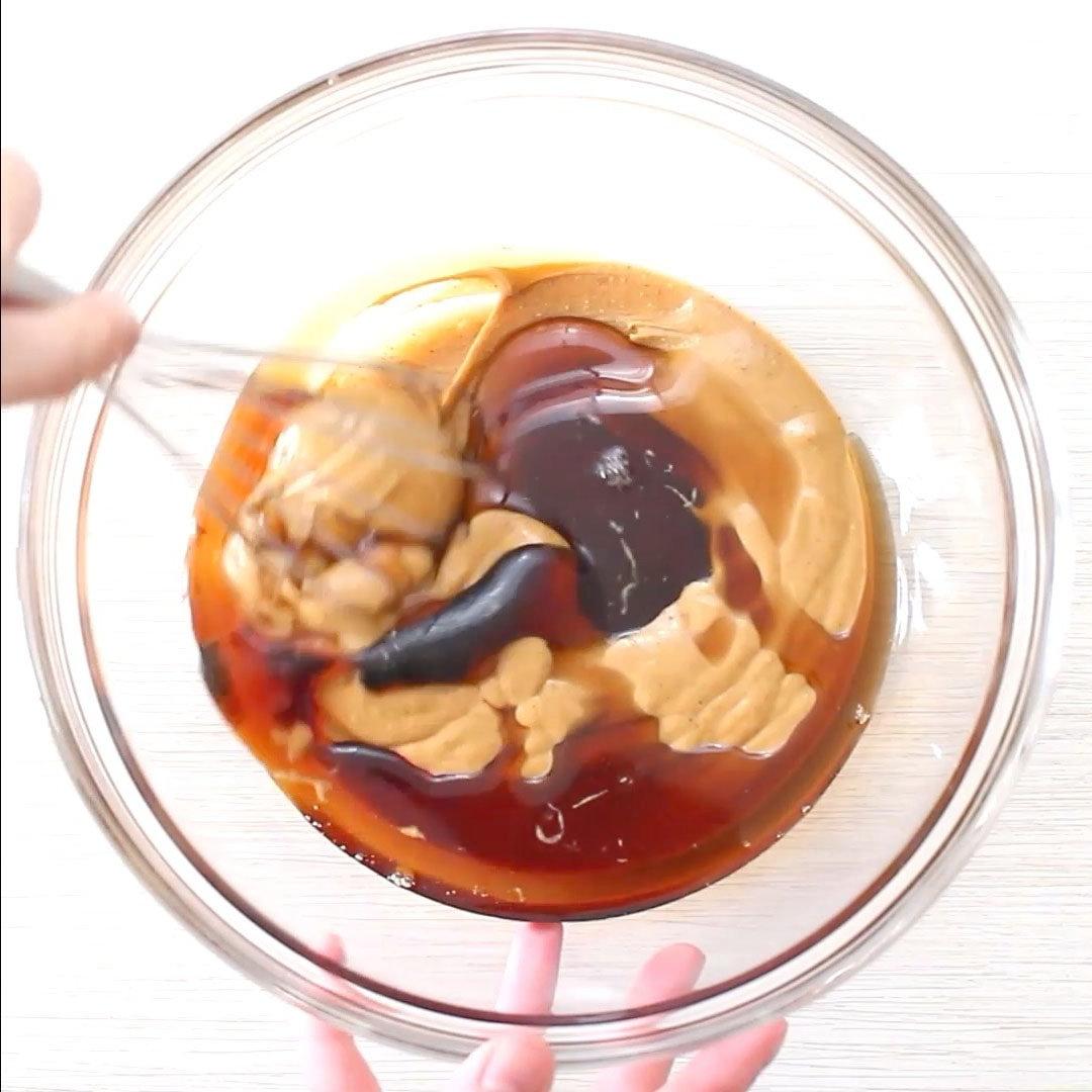 Zubereitung von No Bake Schoko-Haferflocken-Keksen: Erdnussbutter und Ahornsirup werden in einer Schüssel verrührt.