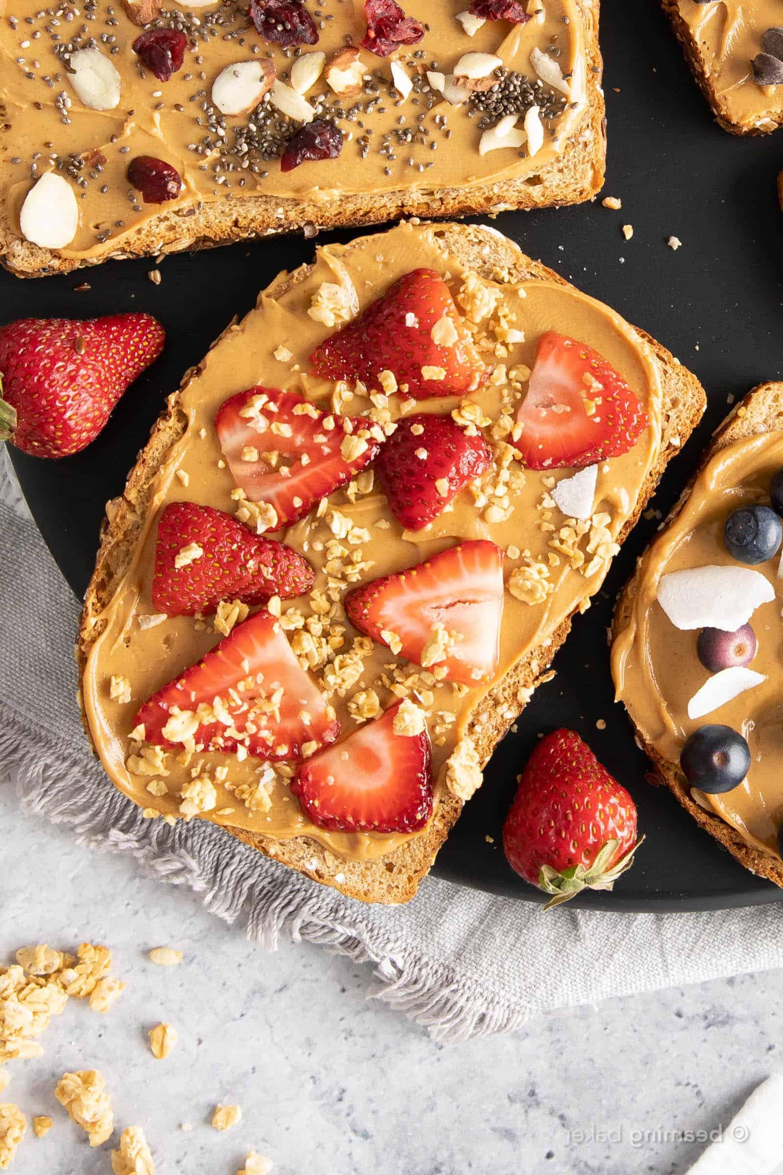 Erdbeer-Granola Erdnussbutter-Toast mit Erdbeerscheiben und Granola bestreut