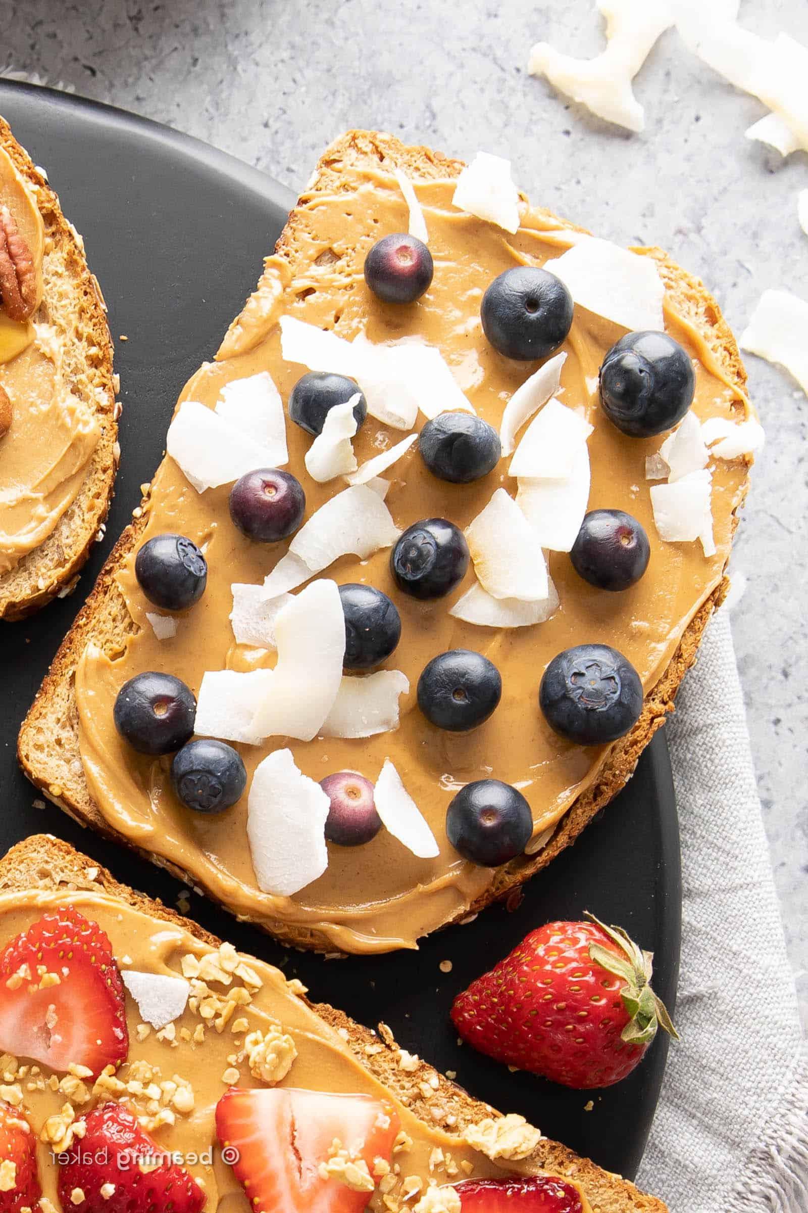 Heidelbeer-Kokos-Erdnussbutter-Toast mit frischen Heidelbeeren und Kokoschips