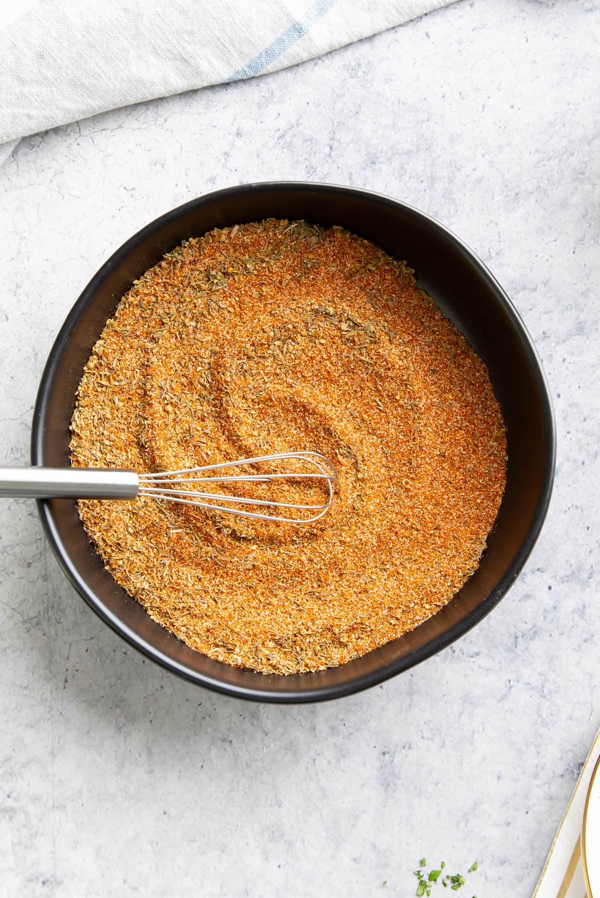 Cajun-Gewürzmischung Rezept 5 Gewürze, die in einer Gewürzschale mit einem Löffel vollständig vermischt sind.