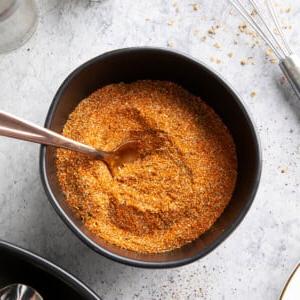 Cajun-Gewürzmischung Rezept 7 Schale mit Cajun-Würzmischung und einem Löffel darin, daneben Gewürze auf dem Tisch.