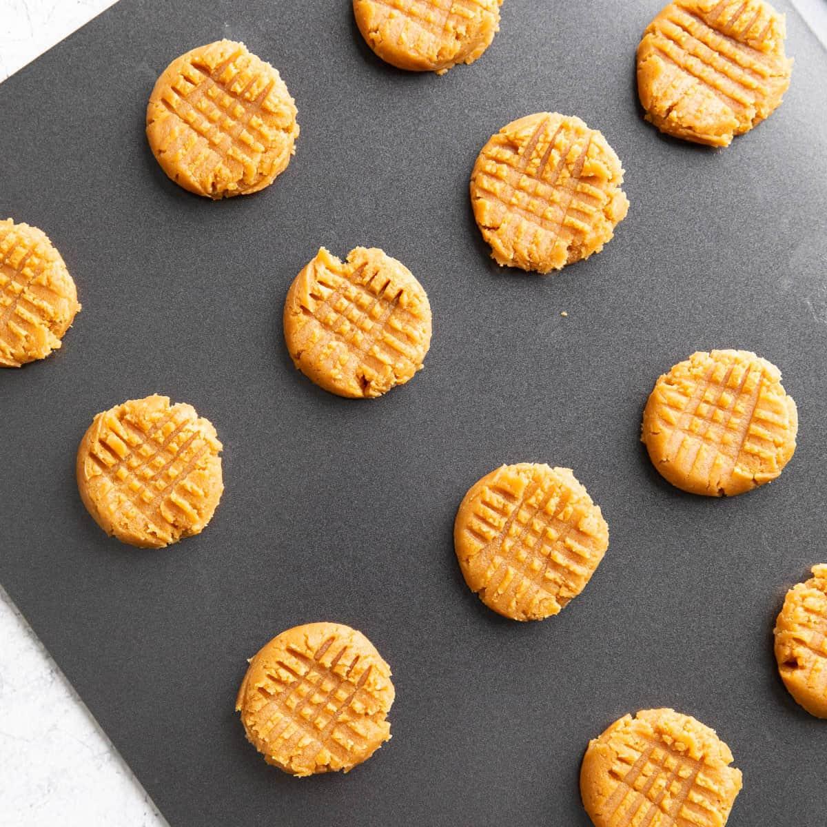 Keto Erdnussbutterkekse 9 Geformter Teig auf dem Backblech, bereit zum Backen
