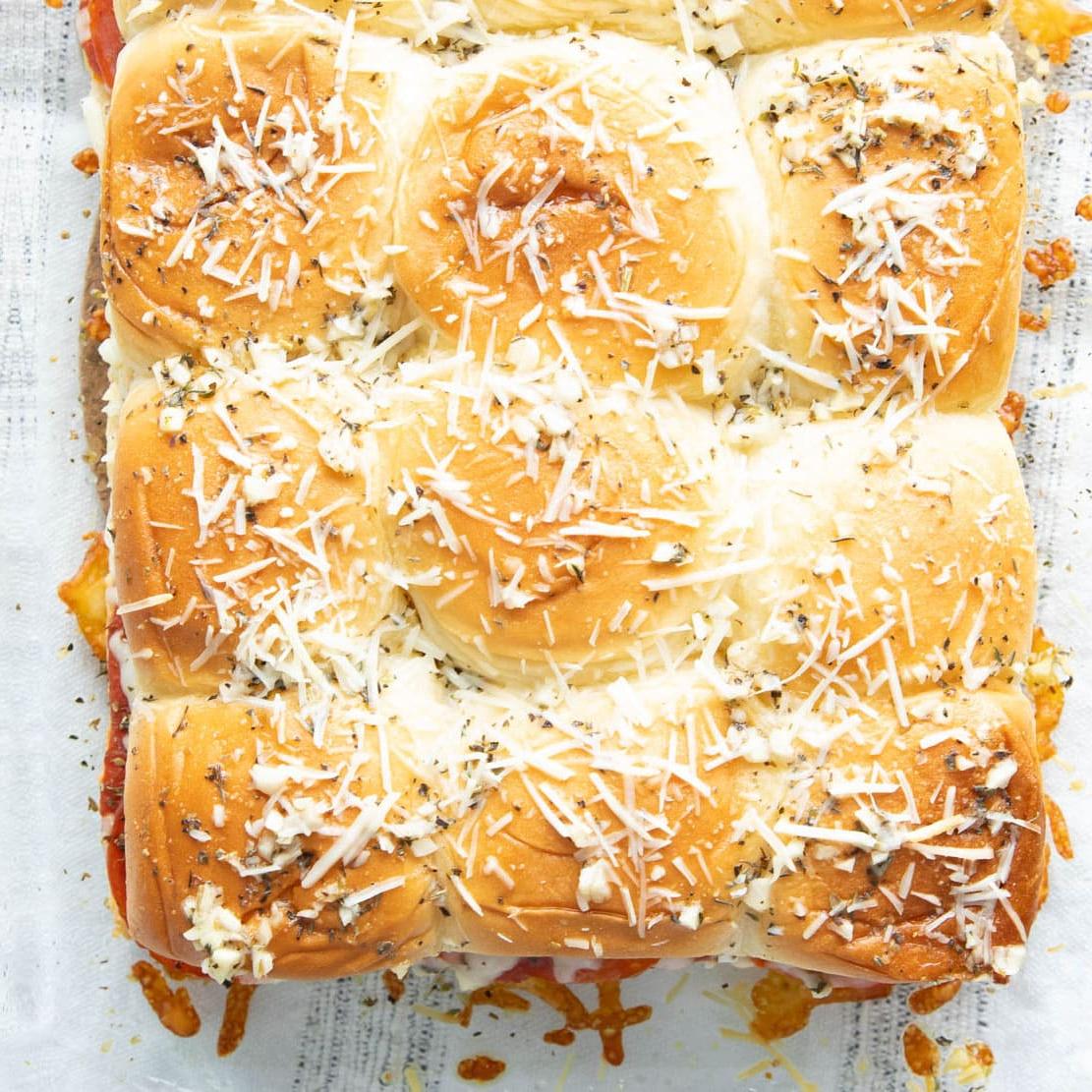 **Pizza-Brötchen** 10 Nahaufnahme von Parmesan, Butter, Knoblauch und Gewürzen, die auf die obere Schicht dieses italienischen Rezepts gebacken wurden