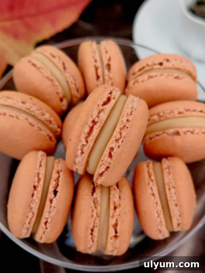 Close-up of golden brown salted caramel macarons with a rich, creamy filling, stacked elegantly.