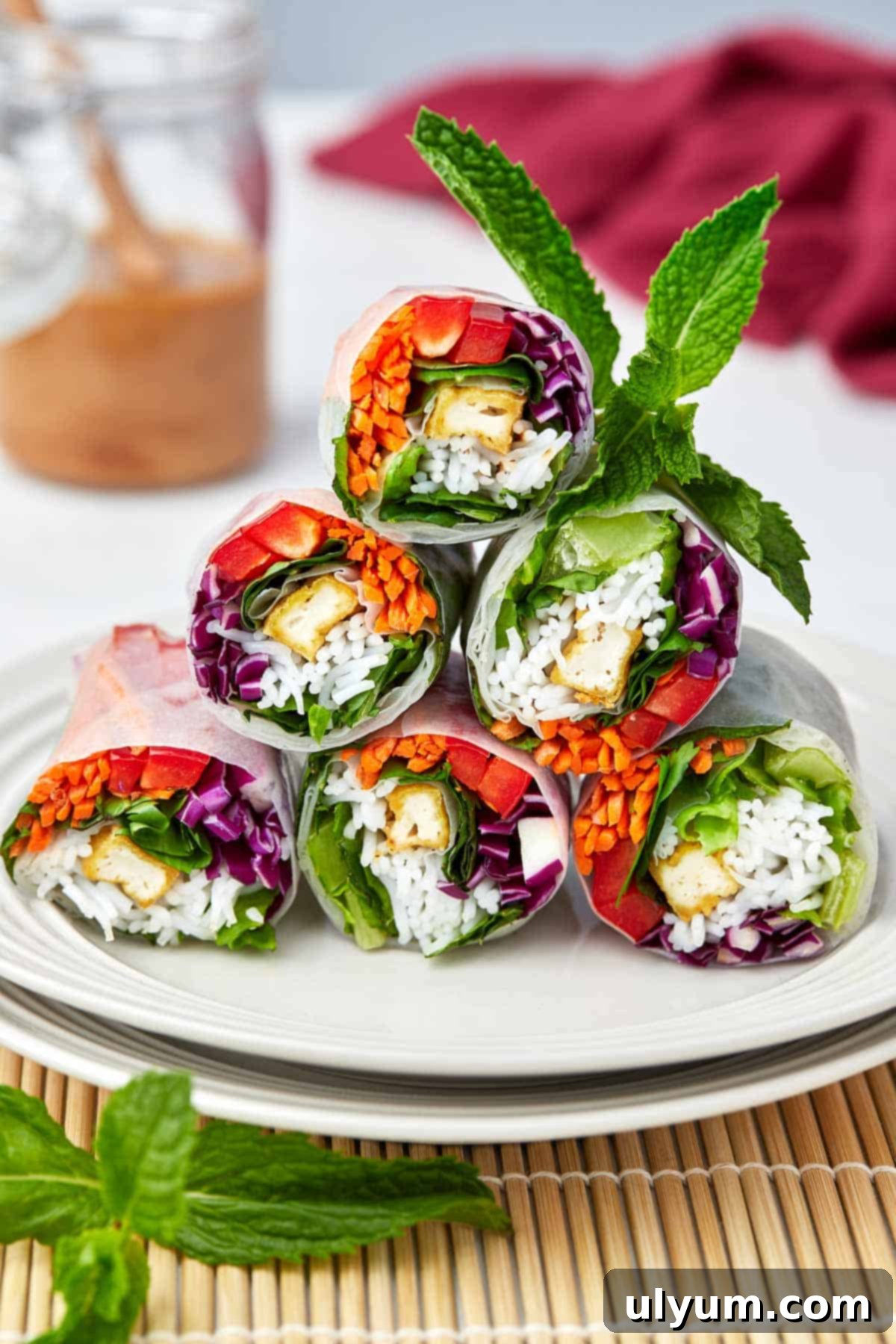 Spring rolls stacked in a pyramid on a serving plate.