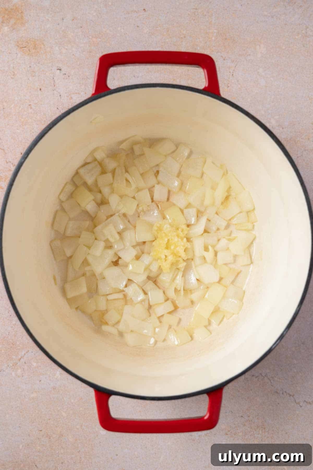 Minced garlic cloves being sautéed in a pot.