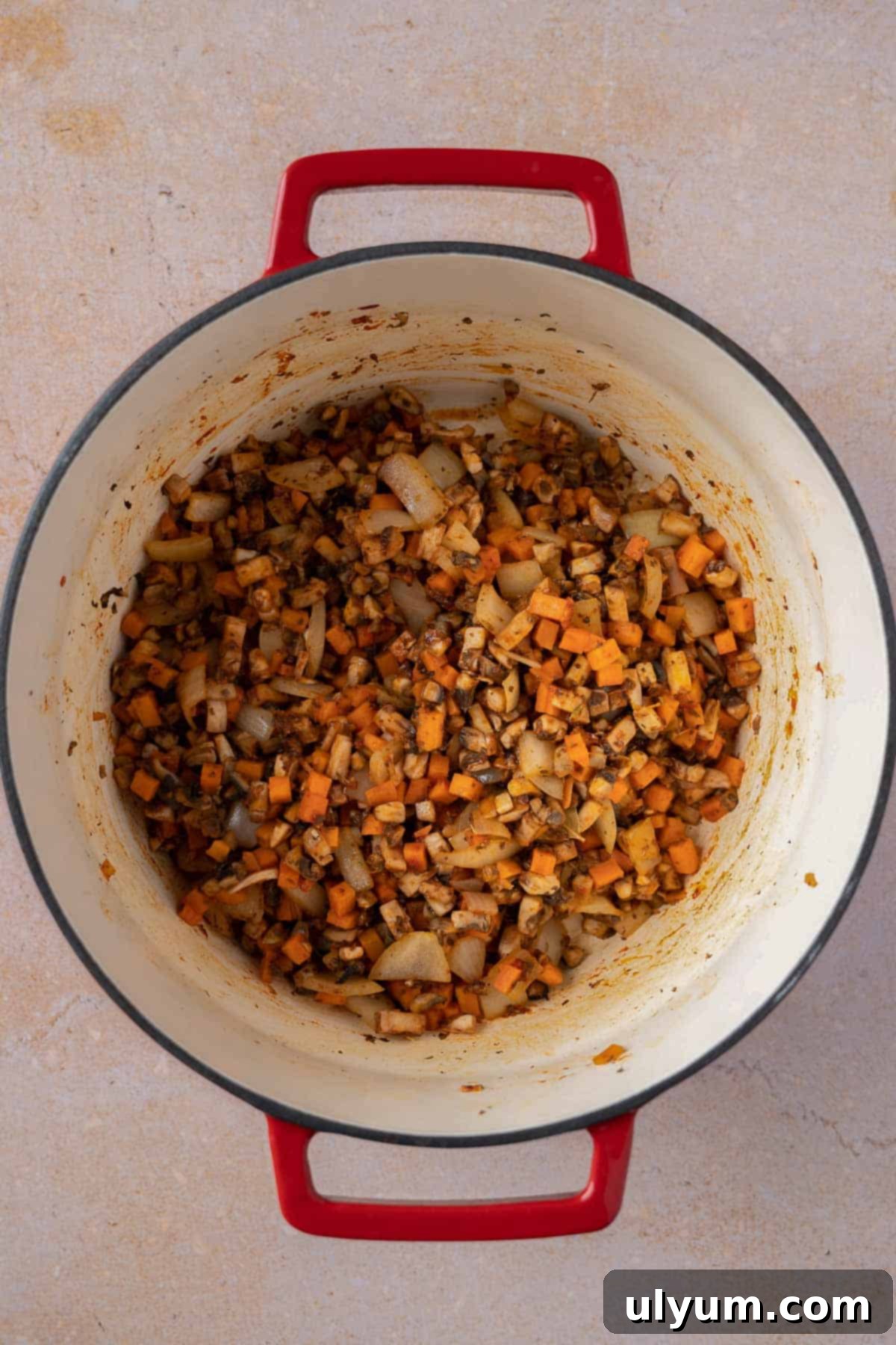 Diced carrots and mushrooms cooking down in the tomato-based sauce.
