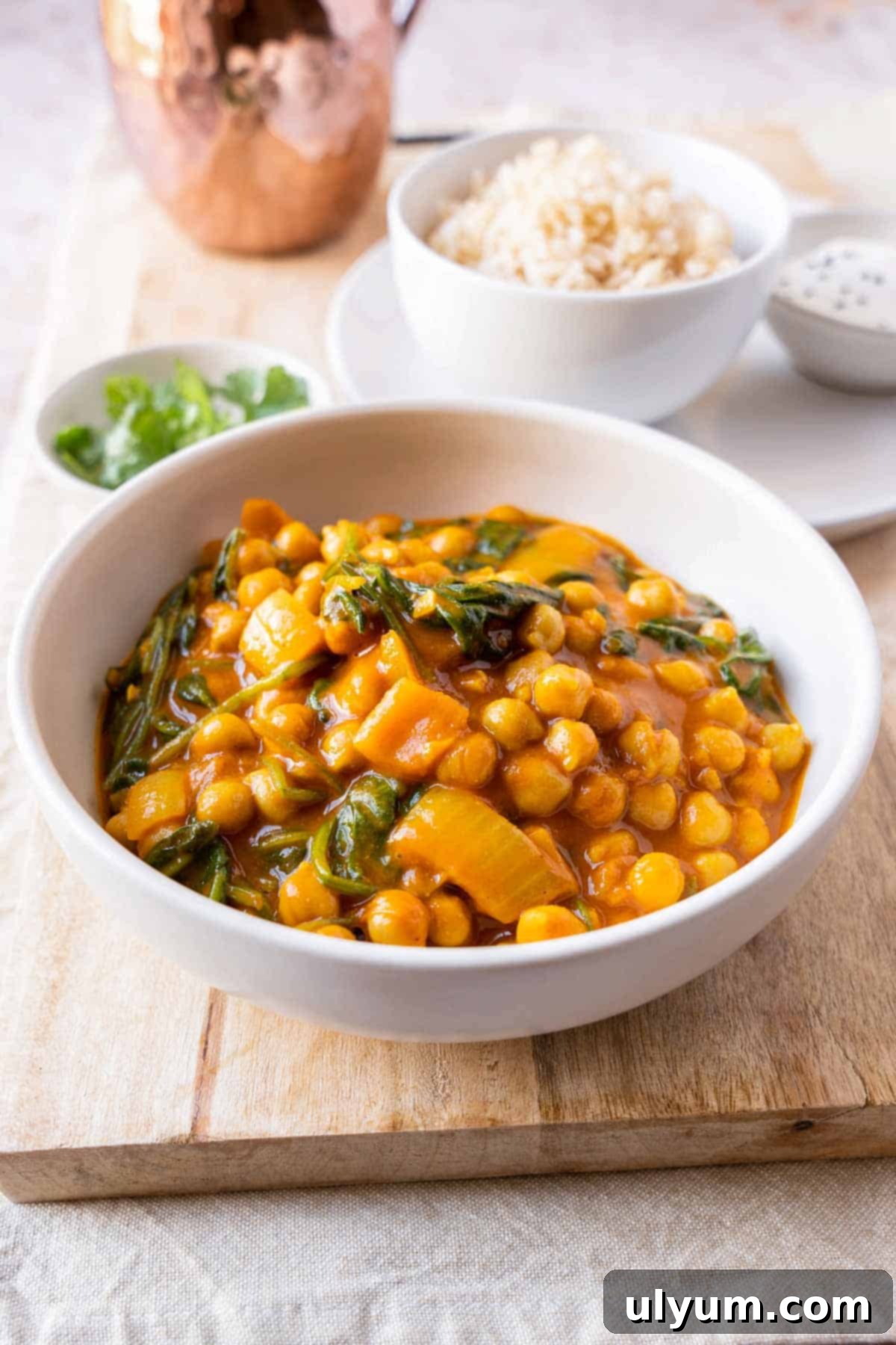 Vibrant Coconut Chickpea & Spinach Curry 12 A bowl of creamy chickpea and spinach curry, ready to be served, garnished with fresh herbs.