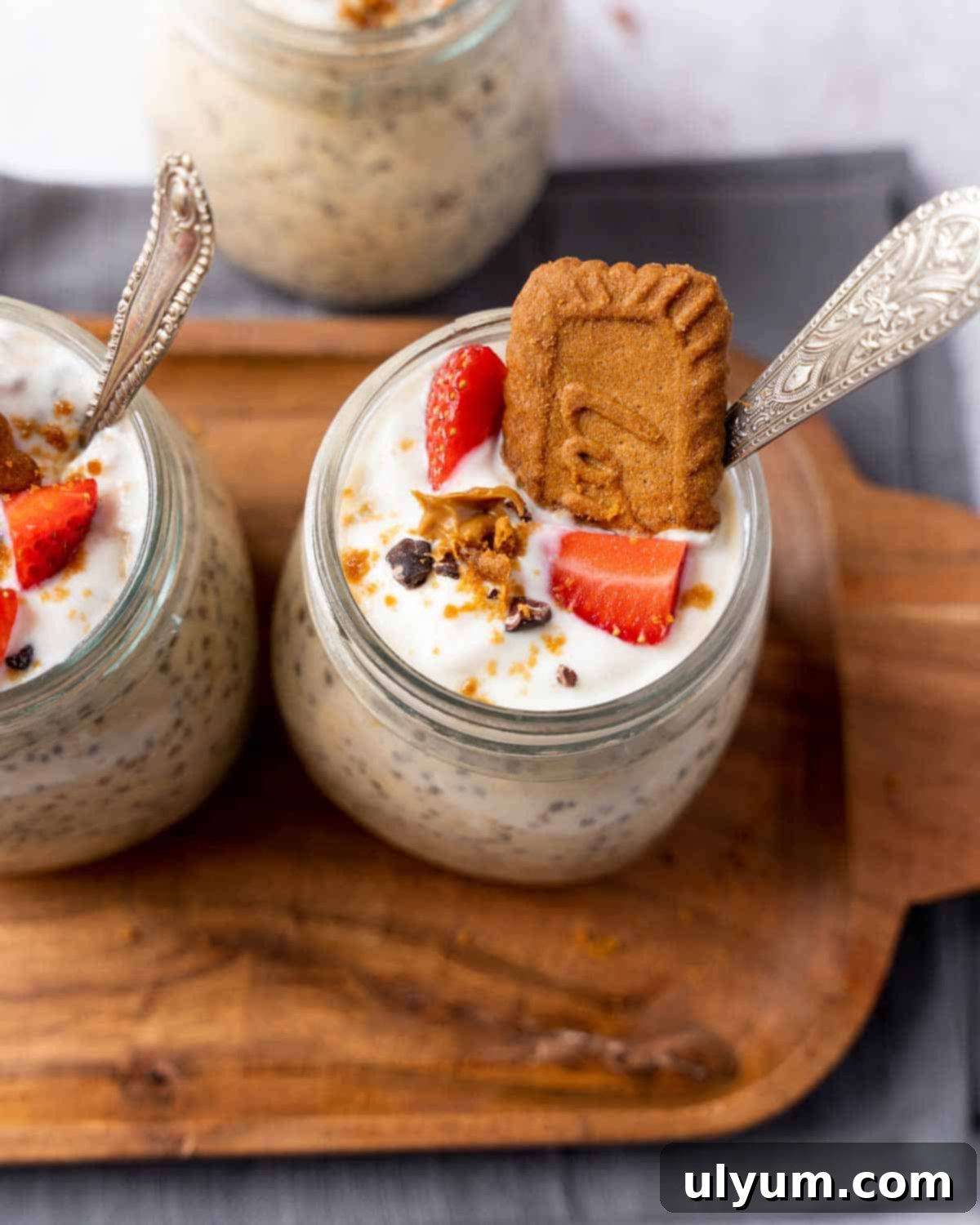 Overnight Cookie Butter Magic 8 A close-up shot of Biscoff overnight oats generously topped with crumbled cookies, fresh sliced strawberries, creamy vanilla yogurt, and a scattering of mini chocolate chips, in a glass jar.