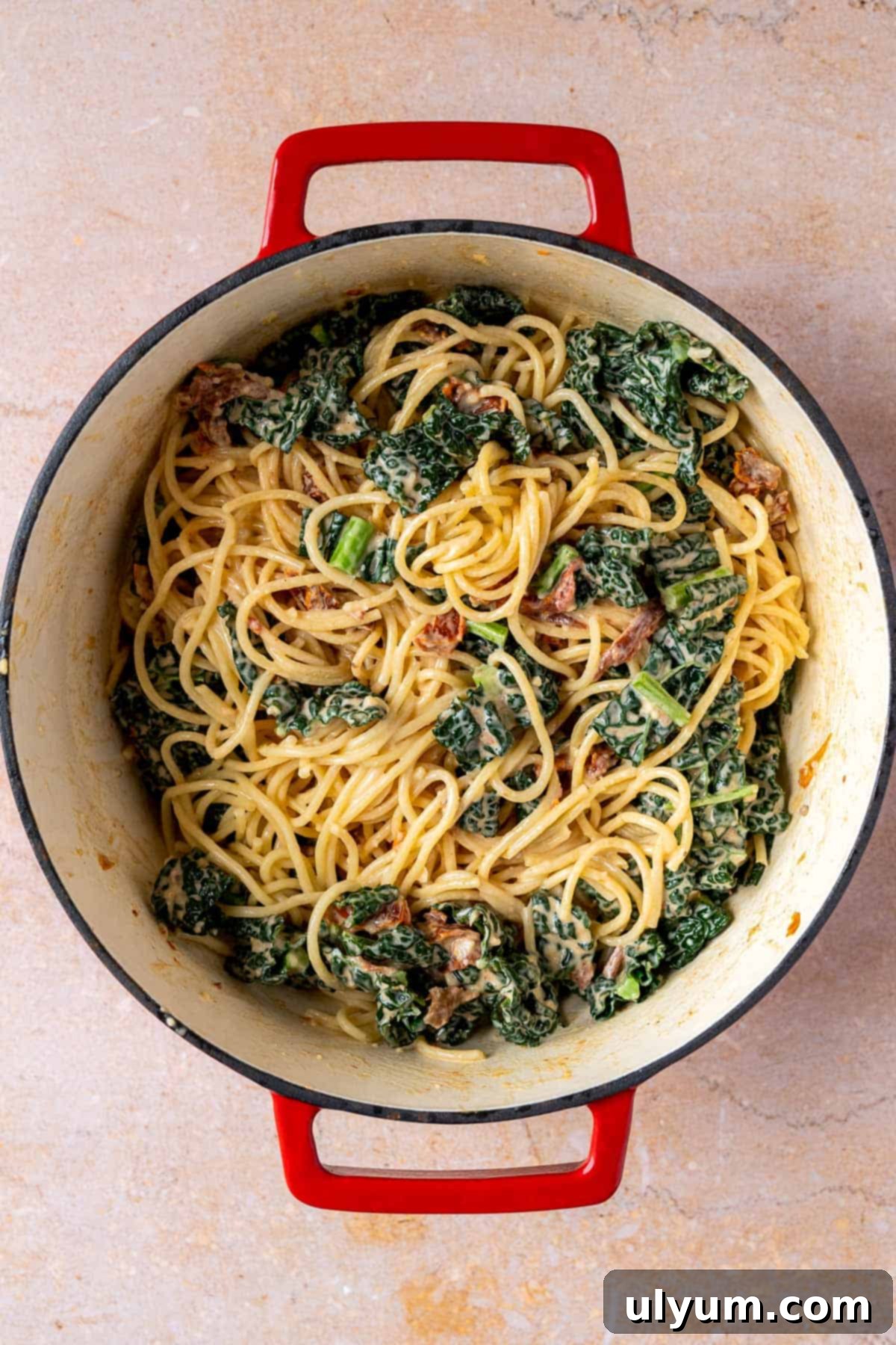 Creamy kale pasta mixed in a Dutch oven.
