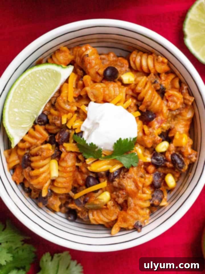 Instant Pot Beef Taco Pasta topped with a dollop of sour cream and a lime wedge.