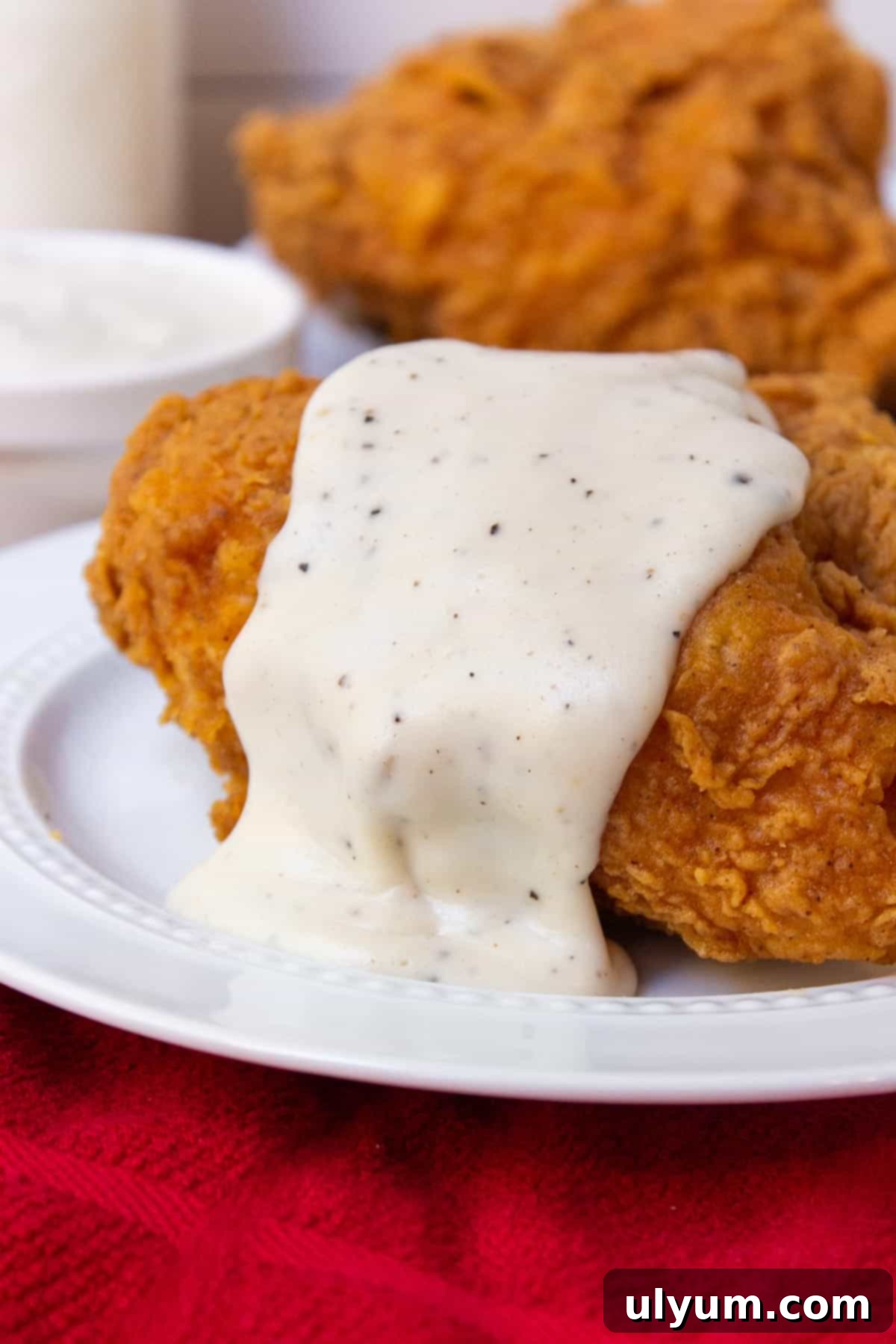 Southern Country Gravy over fried chicken, perfectly golden brown