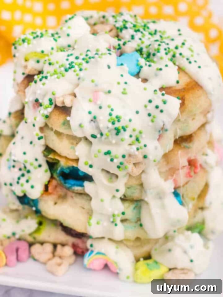 Lucky Charms pancakes topped with cereal marshmallows and syrup.