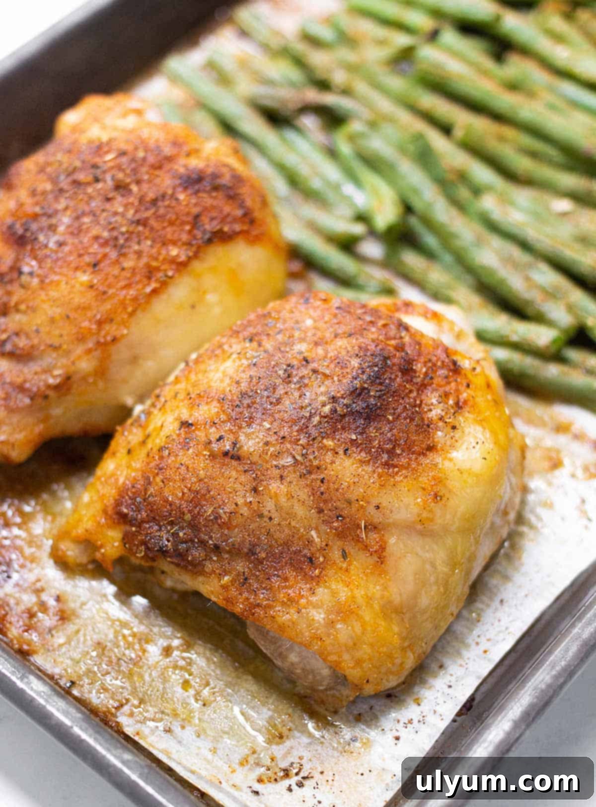 41 Easy Sheet Pan Dinner Ideas 4 Sheet Pan Chicken Thighs with Green Beans. A close-up of golden brown chicken thighs and tender green beans on a sheet pan.