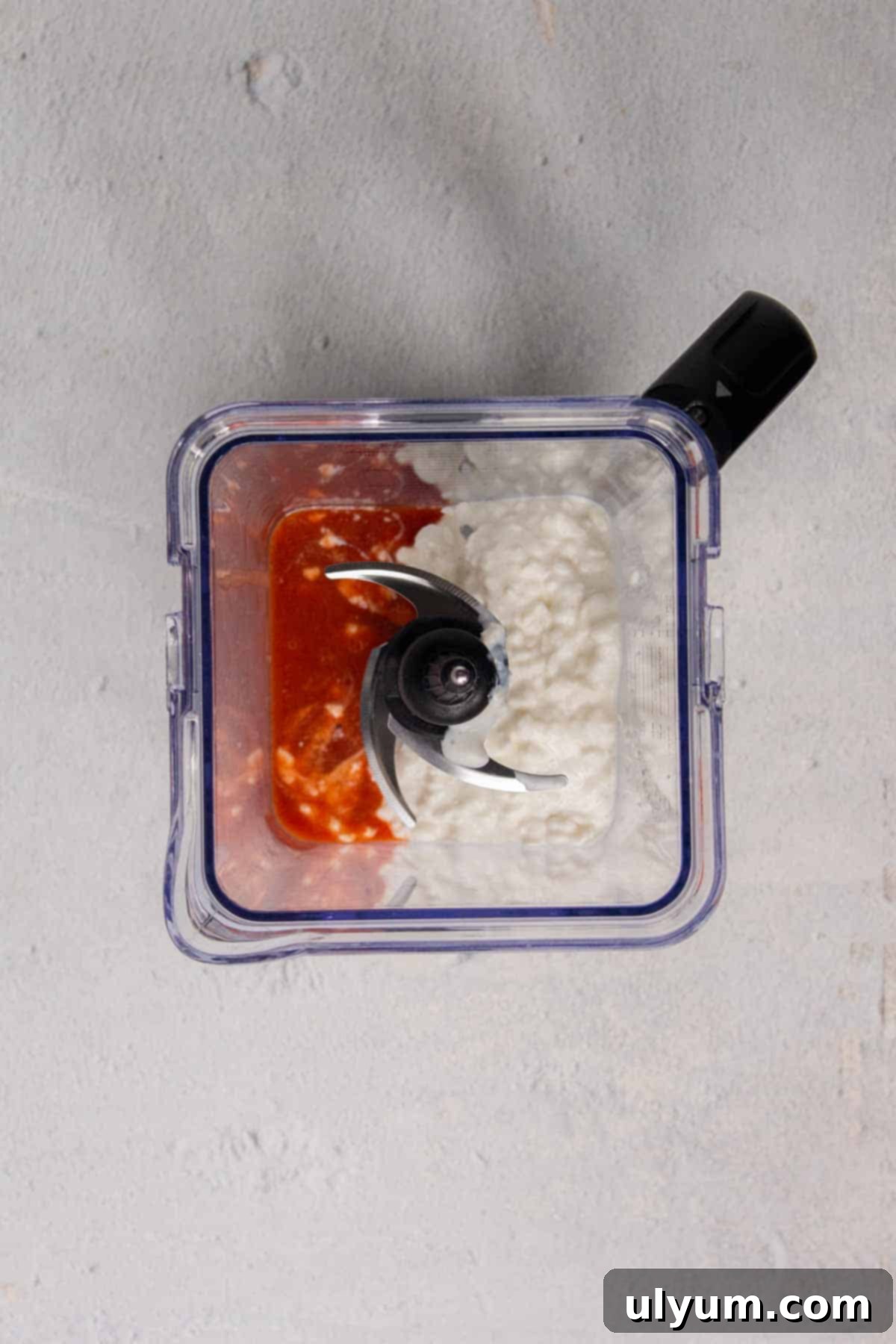 Hot sauce and cottage cheese placed into a blender.