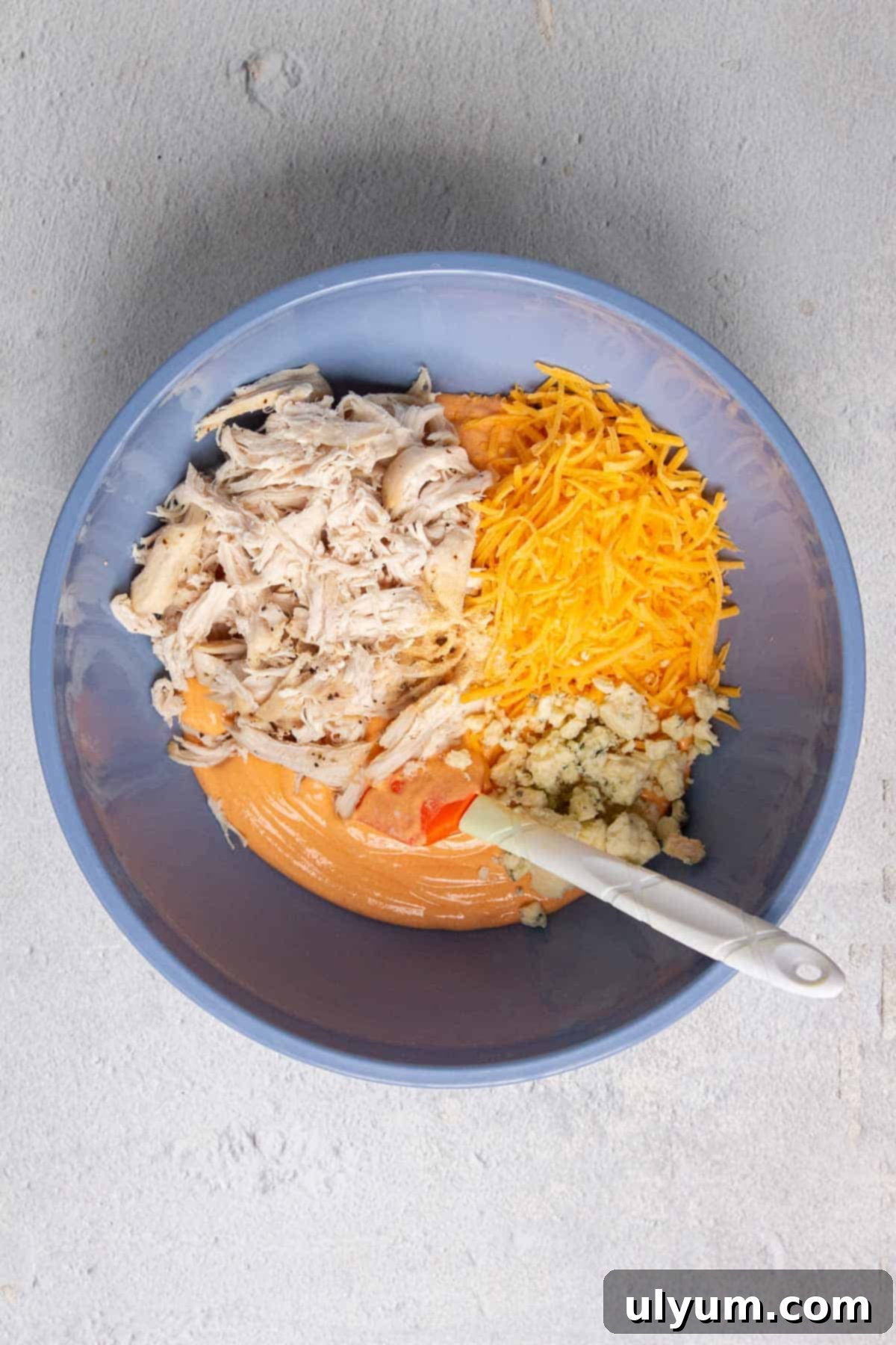 Healthy buffalo chicken dip ingredients in a mixing bowl before combining.