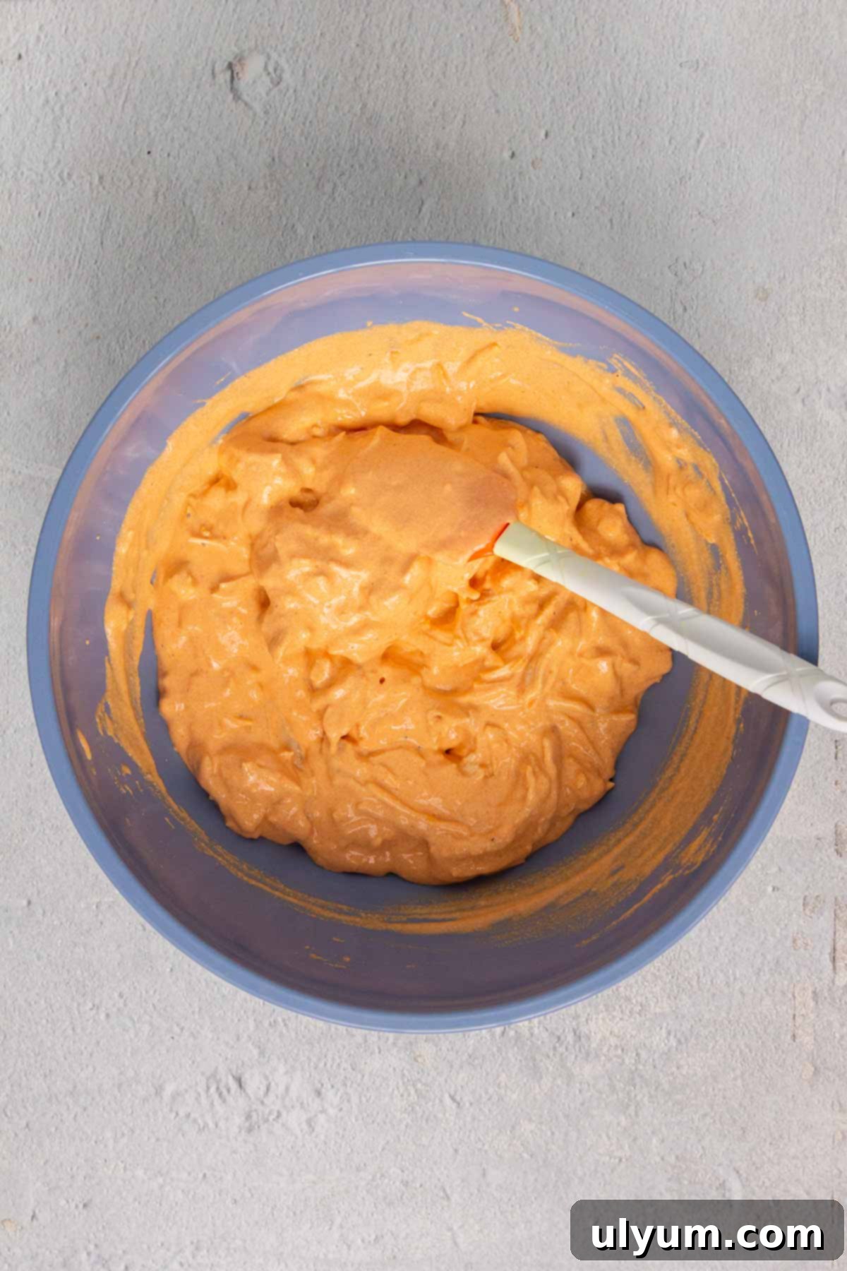 Buffalo dip ingredients combined thoroughly in a mixing bowl.
