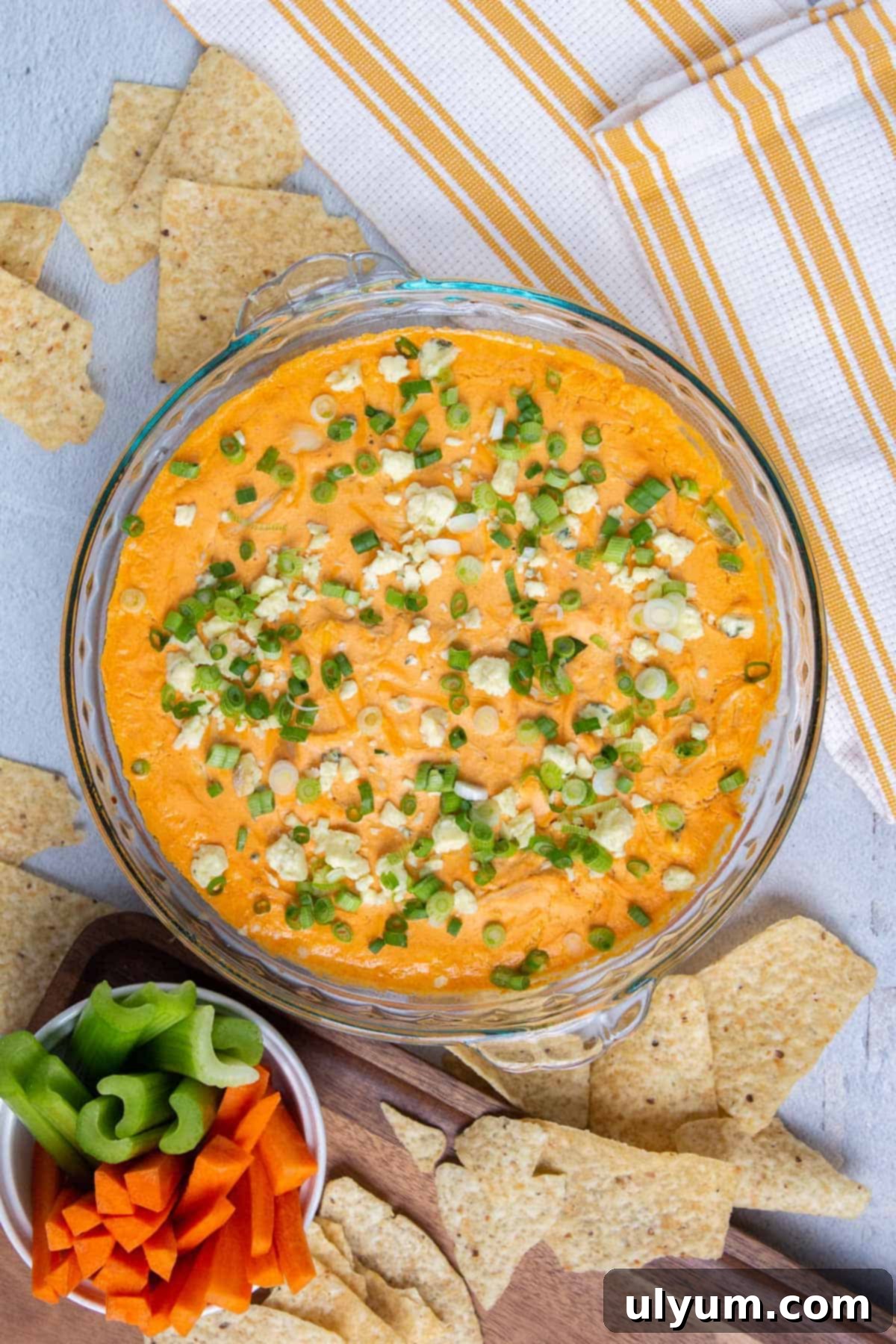Healthy Buffalo Chicken Dip topped with blue cheese crumbles and sliced green onions.