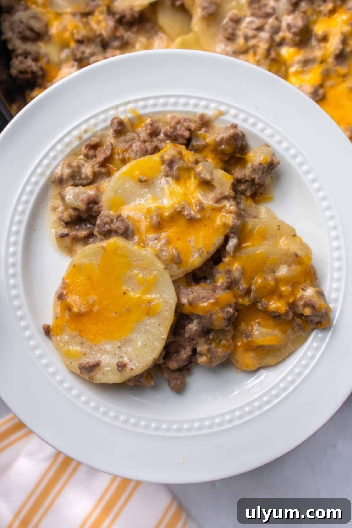 A delicious serving of Crockpot Hamburger Potato Casserole, showcasing the golden melted cheese and tender layers of beef and potatoes.