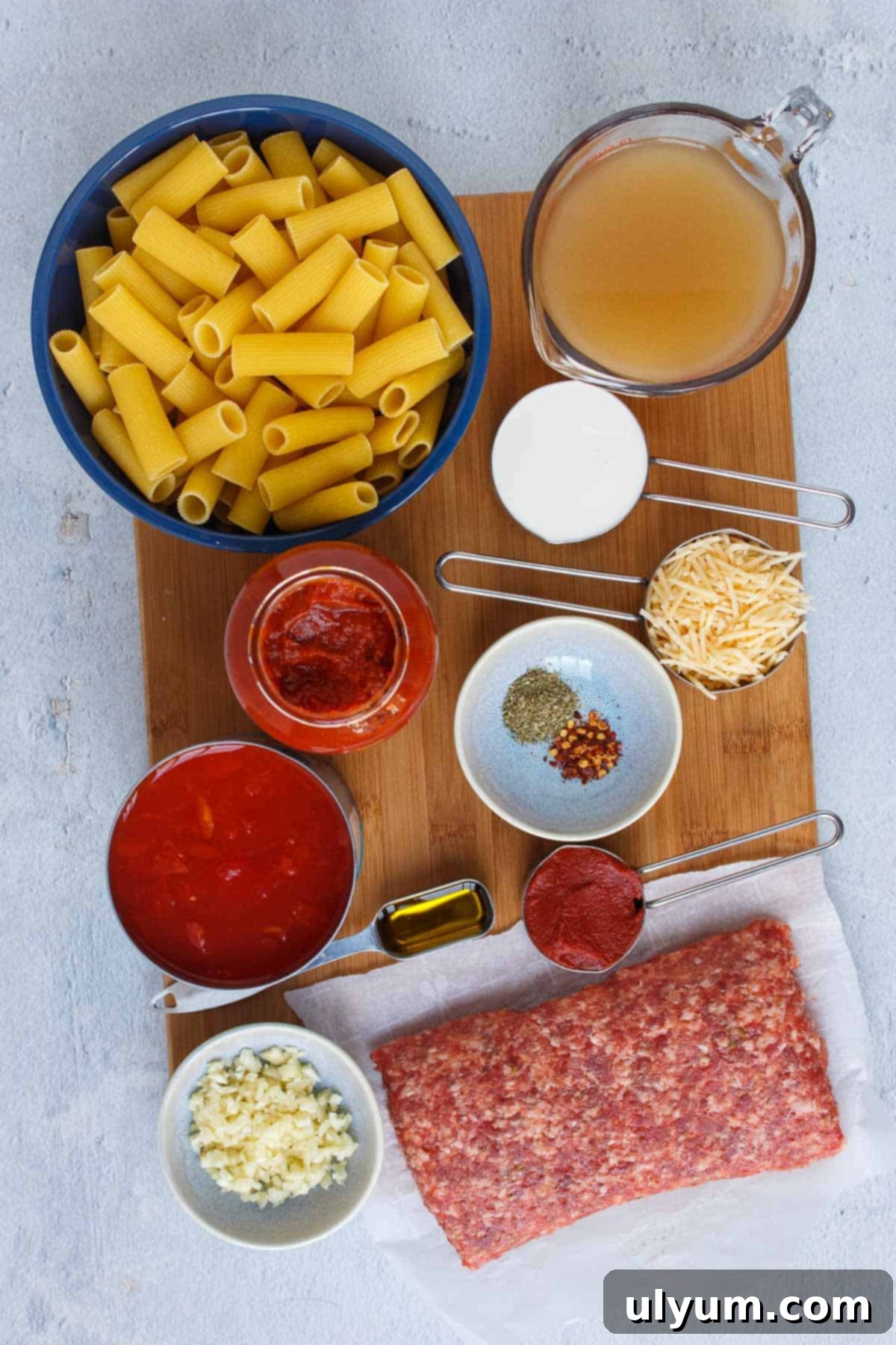 Creamy One-Pot Italian Sausage Pasta 3 Collection of ingredients for Creamy One Pot Rigatoni, including pasta, sausage, tomatoes, and cream.
