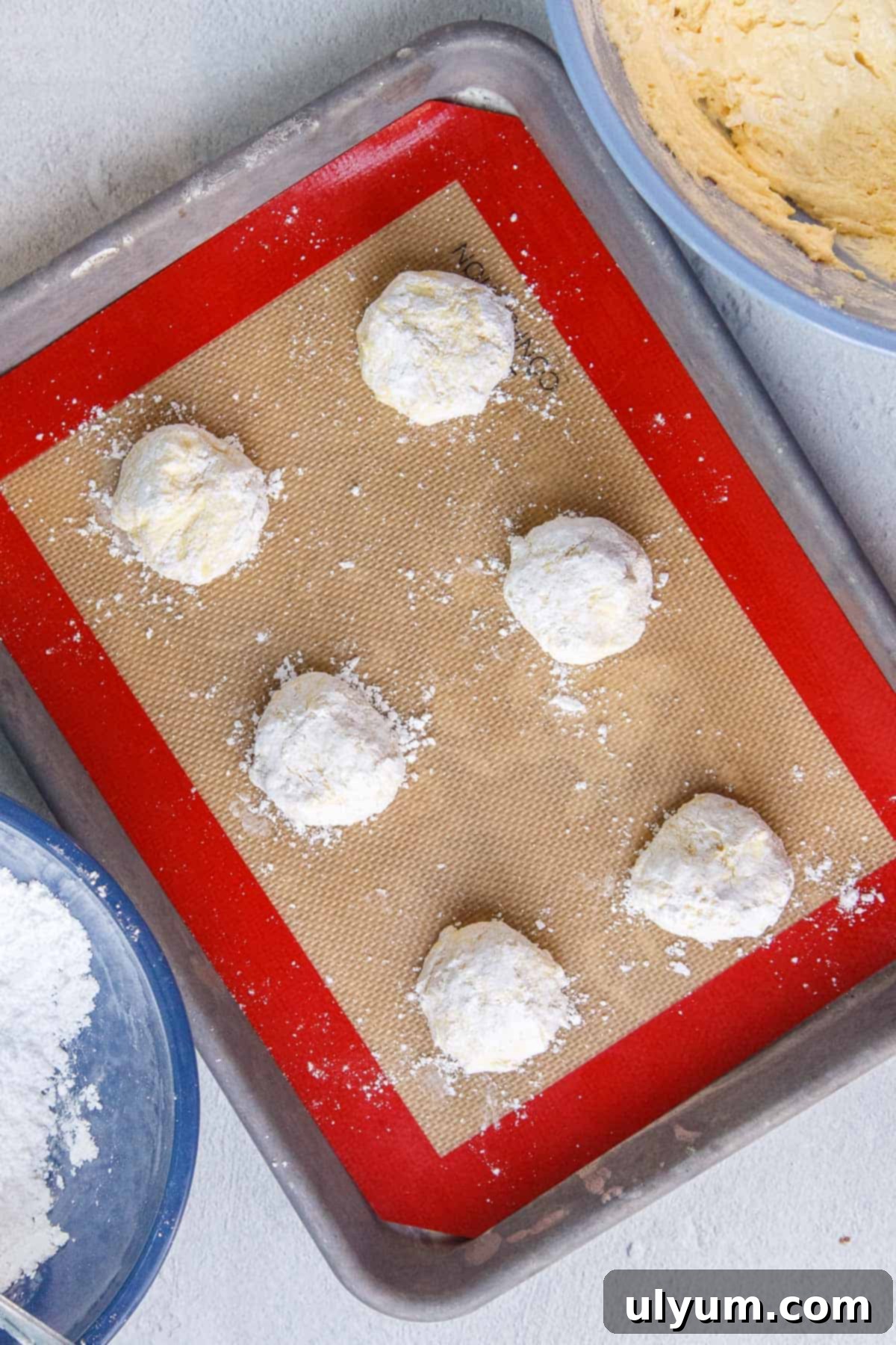 Unbaked Lemon Cool Whip Cookie dough balls on a prepared baking sheet