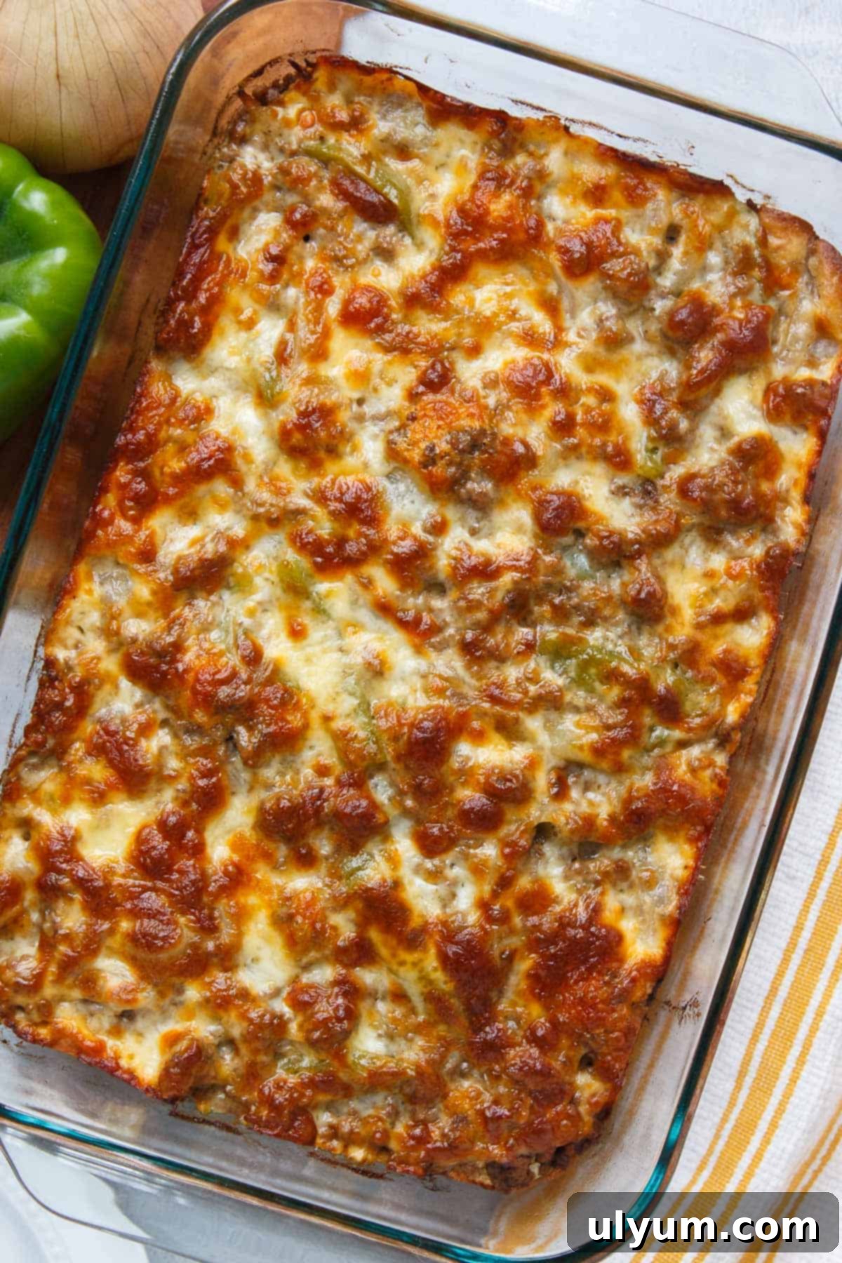 The finished Philly cheesesteak casserole, baked to golden perfection with bubbly melted cheese and a perfectly cooked biscuit base.
