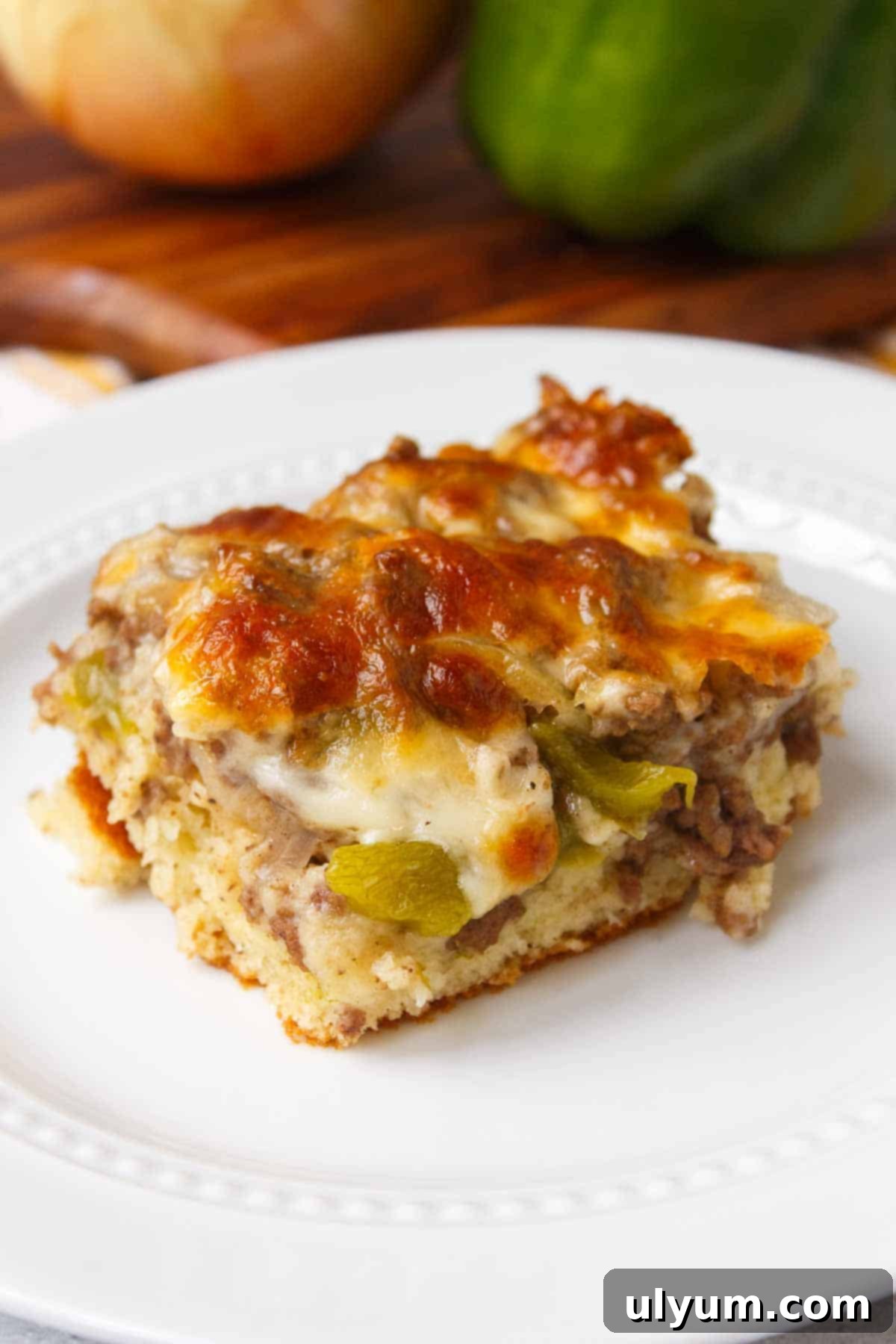 A freshly baked Philly cheesesteak casserole, perfectly golden and bubbly, sliced into servings, inviting you to dig in.