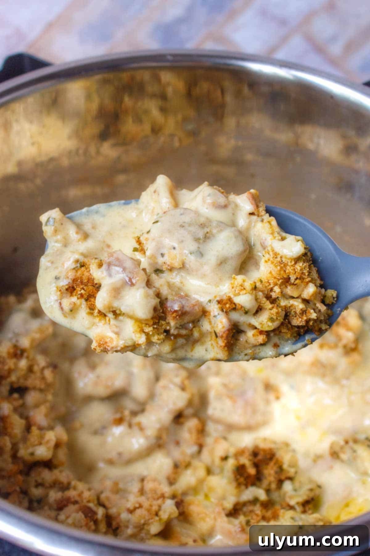 Large serving spoon filled with Instant Pot Chicken Stuffing Casserole, ready to be enjoyed