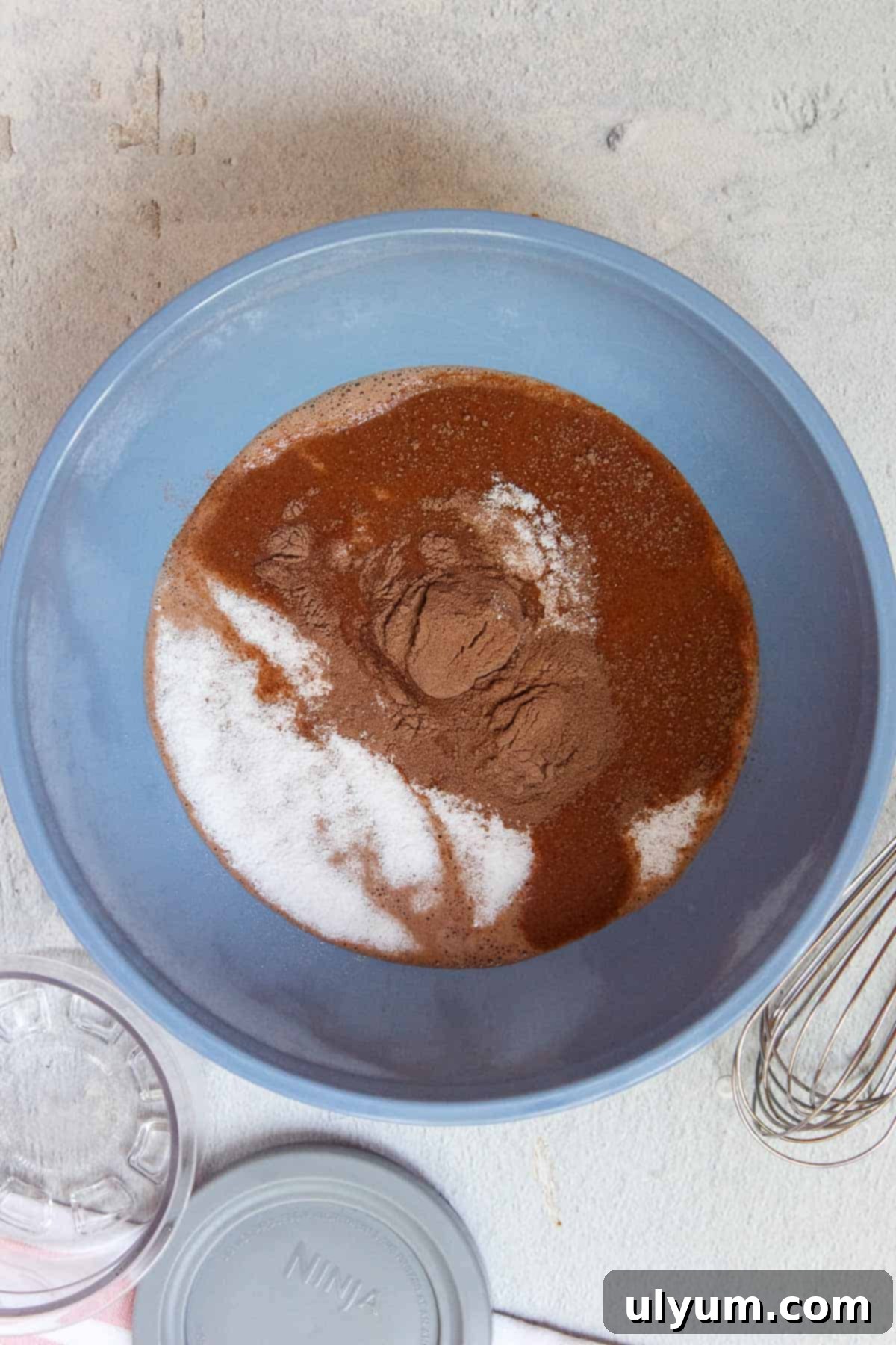 Mixing Fairlife chocolate milk, Stevia, and sugar-free chocolate pudding mix in a bowl for Ninja Creami
