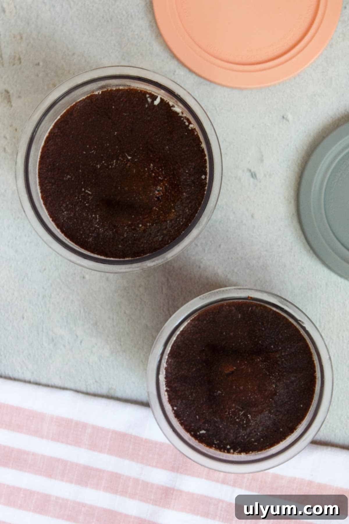 Two Ninja Creami Chocolate Protein Ice Cream pints after freezing the liquid mixture, showing solid frozen state