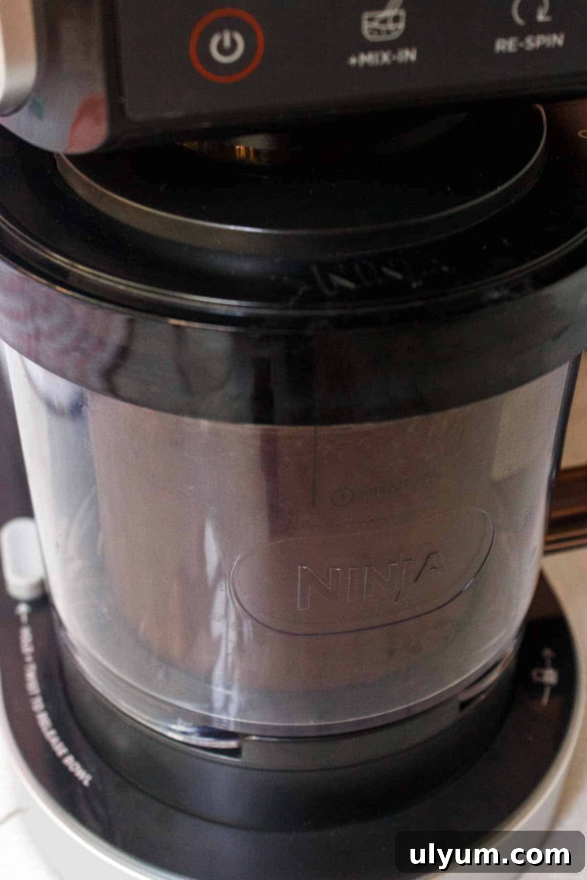 Ninja Creami machine loaded with a pint of frozen chocolate protein ice cream base