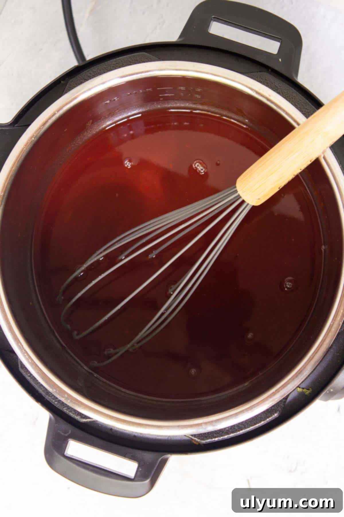Grape jelly, Heinz chili sauce, and water are mixed together in the Instant Pot pot.