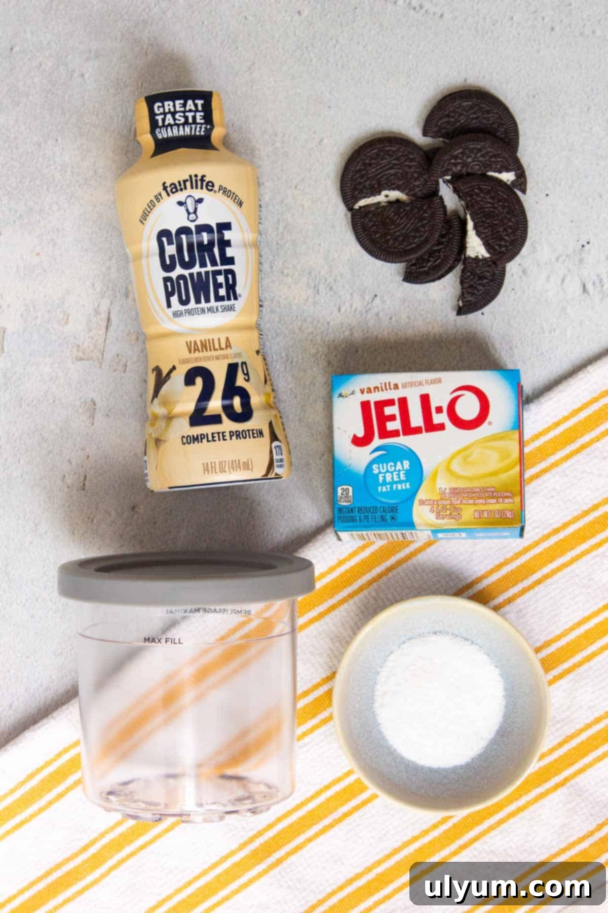 Ninja Creami Oreo Protein Ice Cream ingredients on a countertop, including Fairlife shake, stevia, pudding mix, and Oreo Thins